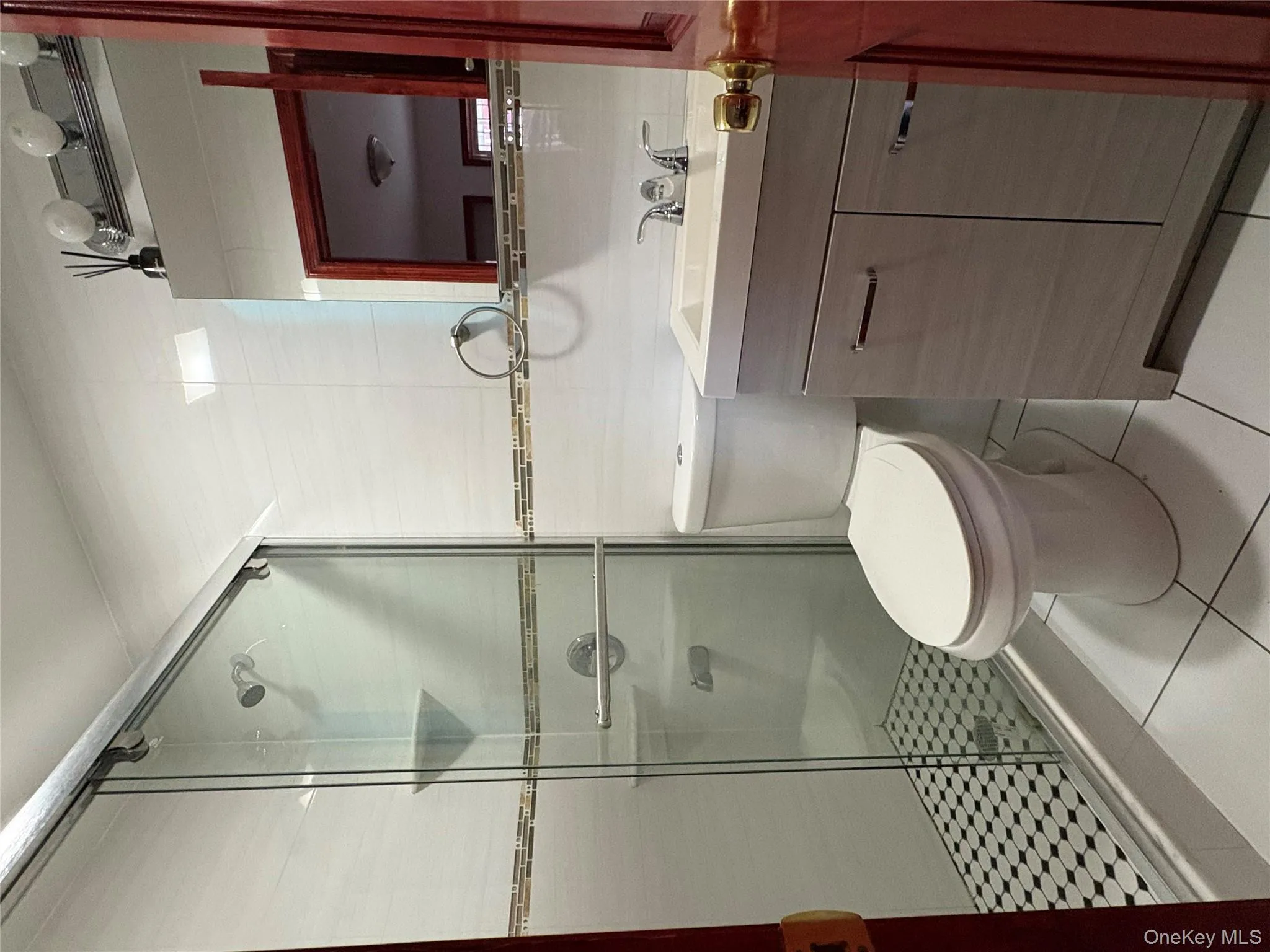 Full bathroom featuring tile walls, light tile patterned floors, a shower stall, and vanity Full bathroom featuring tile walls, light tile patterned floors, a shower stall, and vanity