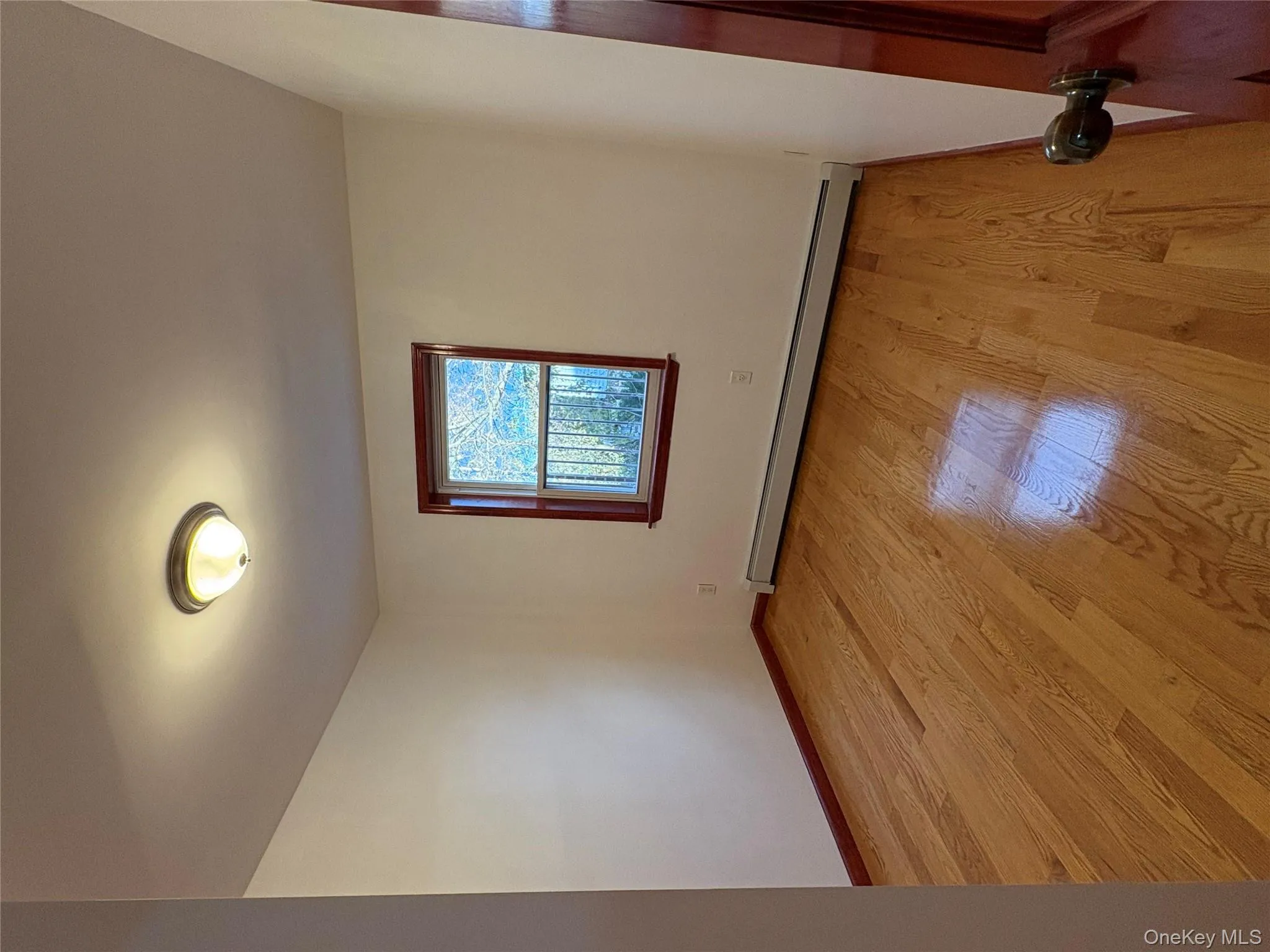 Empty room featuring light wood-type flooring and a baseboard radiator Empty room featuring light wood-type flooring and a baseboard radiator