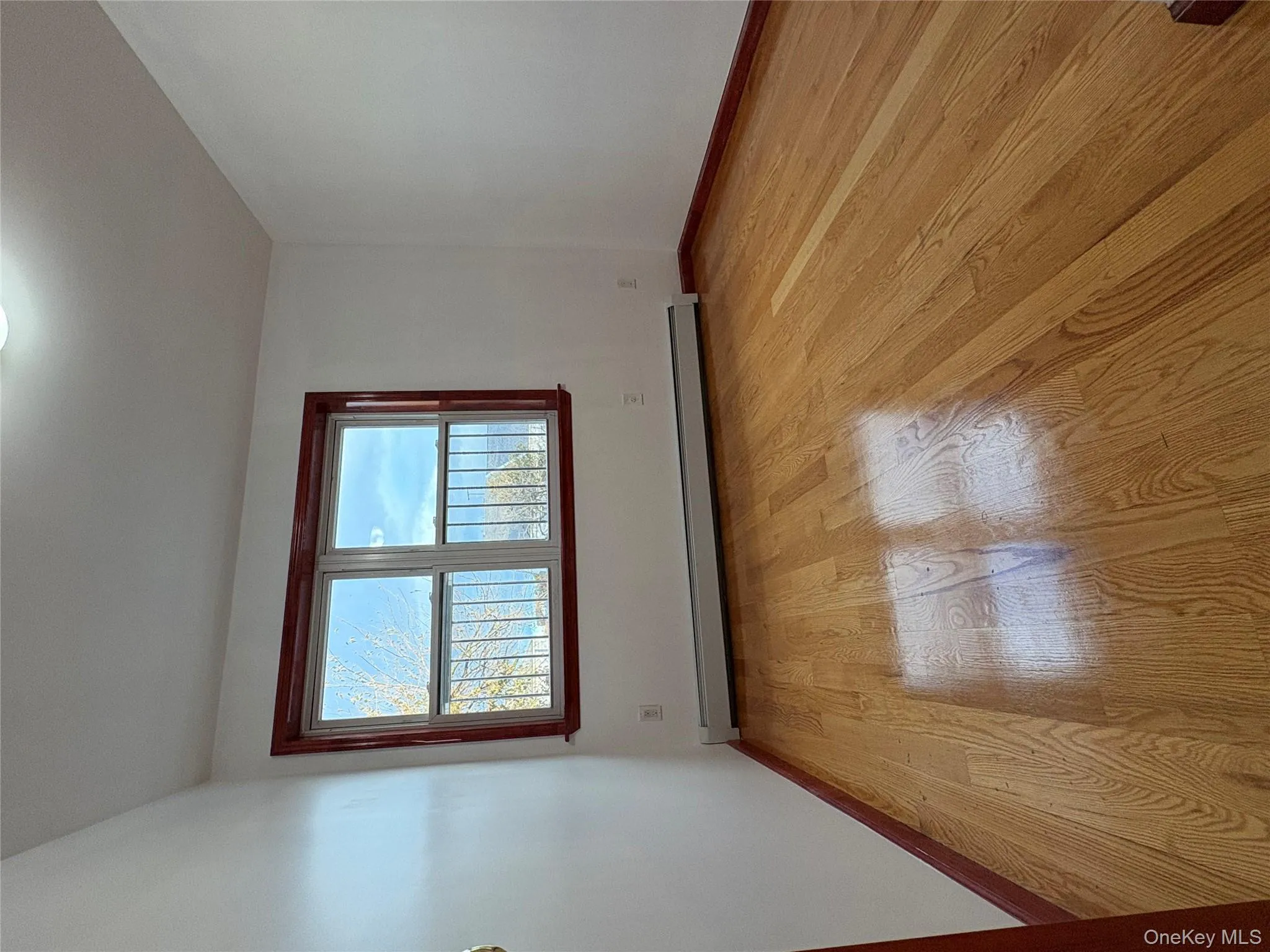 Unfurnished room with plenty of natural light, light wood finished floors, and a baseboard radiator Unfurnished room with plenty of natural light, light wood finished floors, and a baseboard radiator