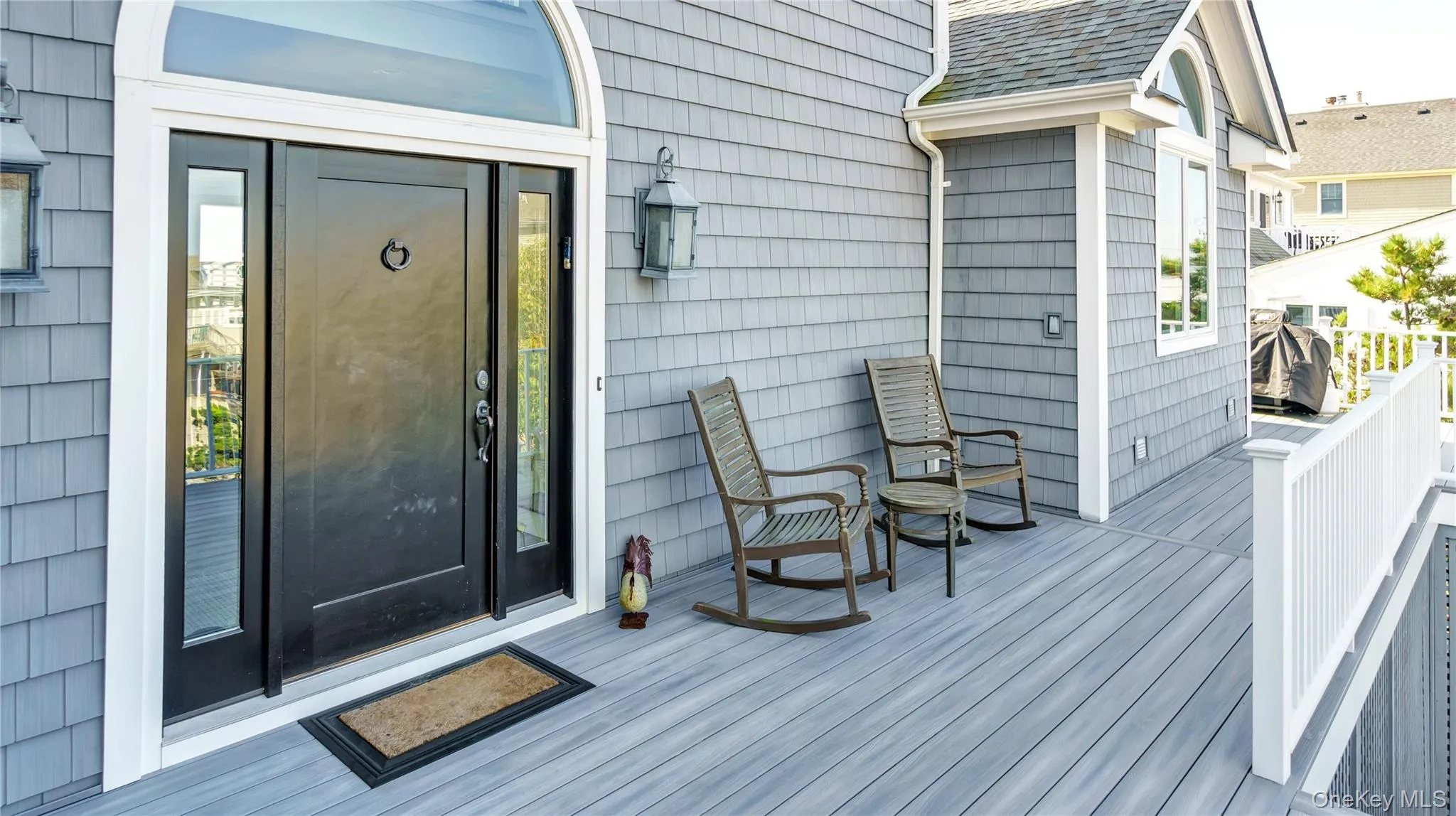 Doorway to property with a deck and roof with shingles Doorway to property with a deck and roof with shingles