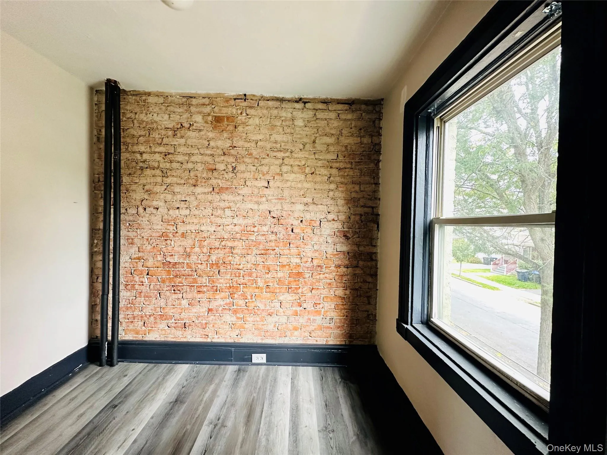 Empty room with brick wall and wood finished floors Empty room with brick wall and wood finished floors