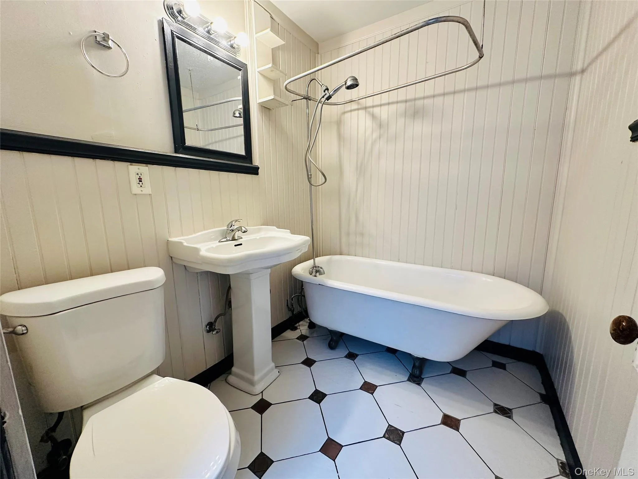 Bathroom featuring a combined bath / shower with freestanding tub and tile patterned flooring Bathroom featuring a combined bath / shower with freestanding tub and tile patterned flooring