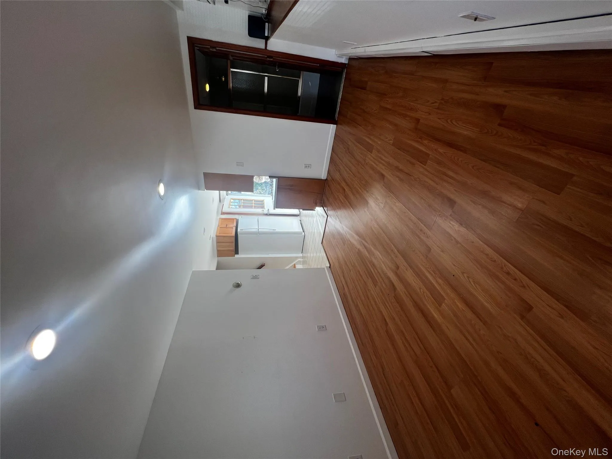 Unfurnished living room with dark wood-style flooring, recessed lighting, and a baseboard heating unit Unfurnished living room with dark wood-style flooring, recessed lighting, and a baseboard heating unit