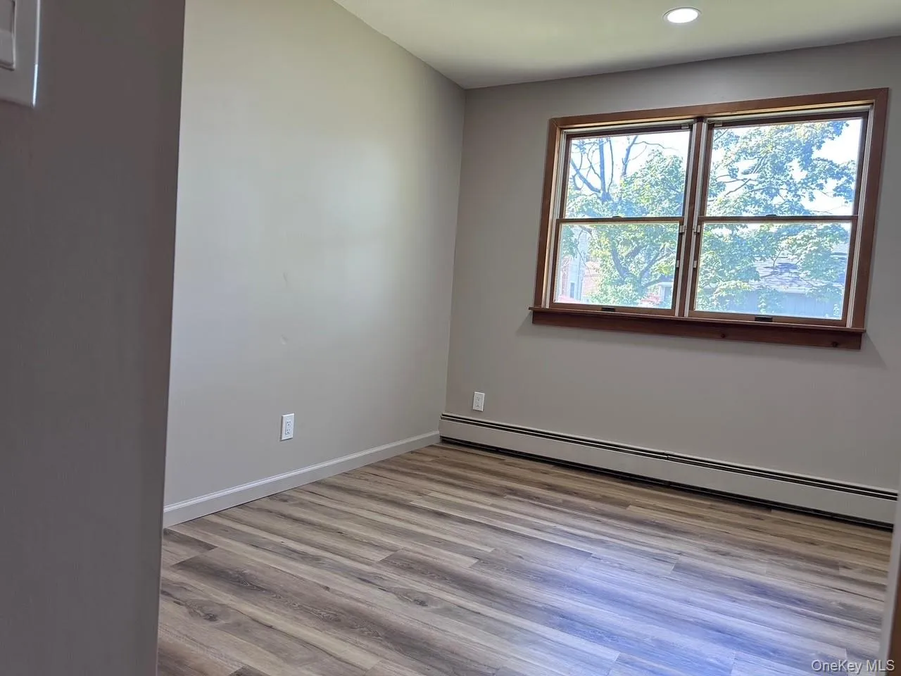 Unfurnished room featuring a baseboard heating unit, light wood-style flooring, and recessed lighting Unfurnished room featuring a baseboard heating unit, light wood-style flooring, and recessed lighting