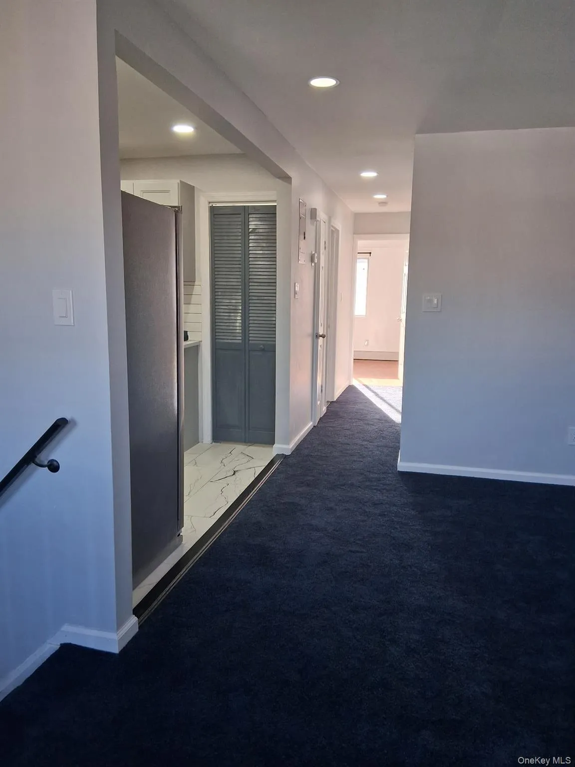 Corridor featuring light colored carpet, recessed lighting, and light marble finish floors Corridor featuring light colored carpet, recessed lighting, and light marble finish floors