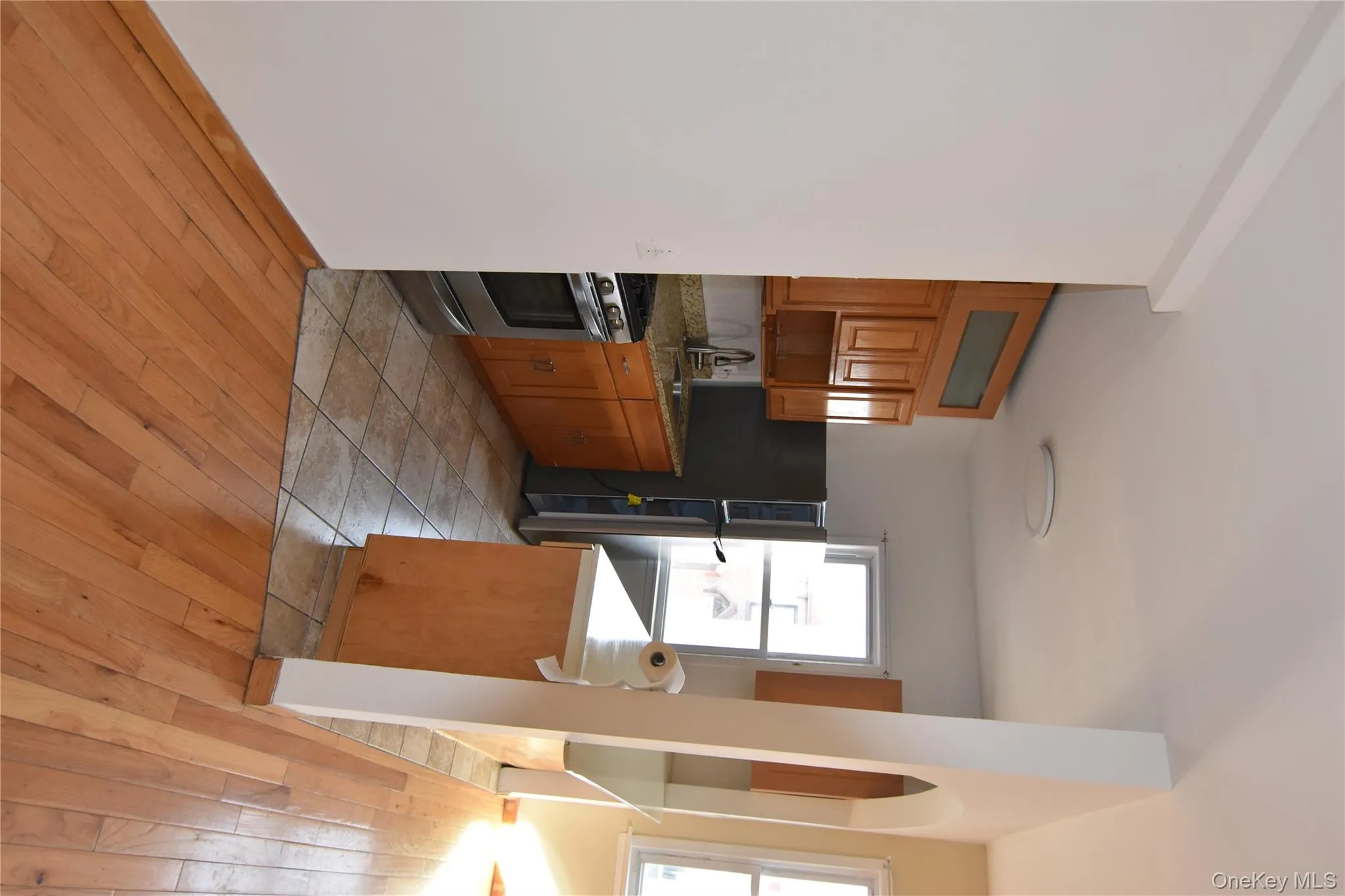 Kitchen with brown cabinets, light wood-style floors, range, and freestanding refrigerator Kitchen with brown cabinets, light wood-style floors, range, and freestanding refrigerator