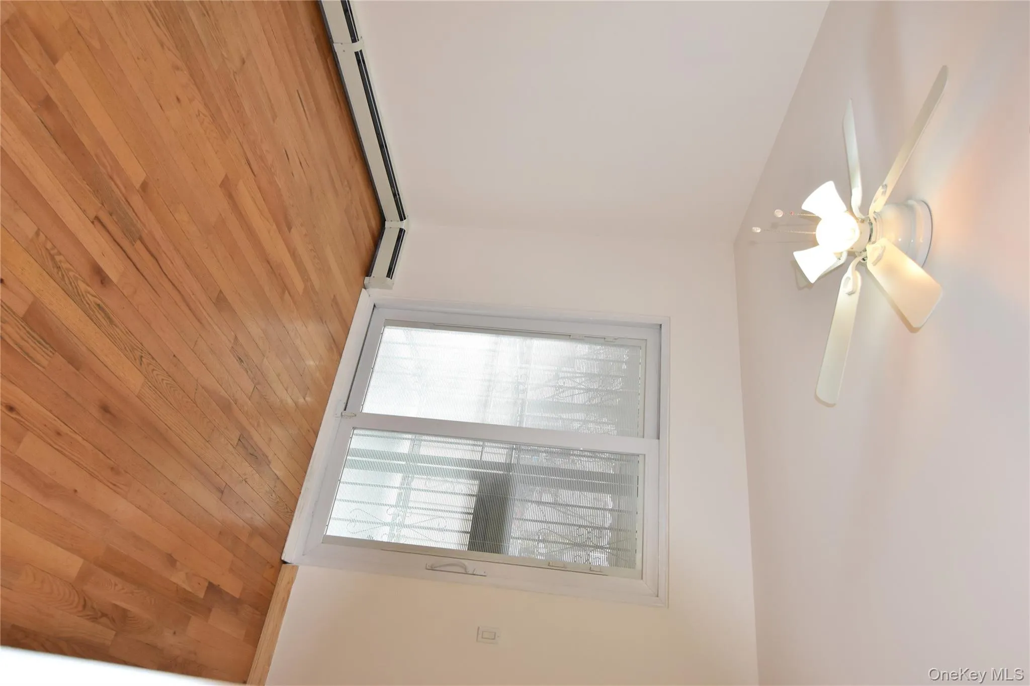 Empty room featuring light wood-style flooring and a ceiling fan Empty room featuring light wood-style flooring and a ceiling fan