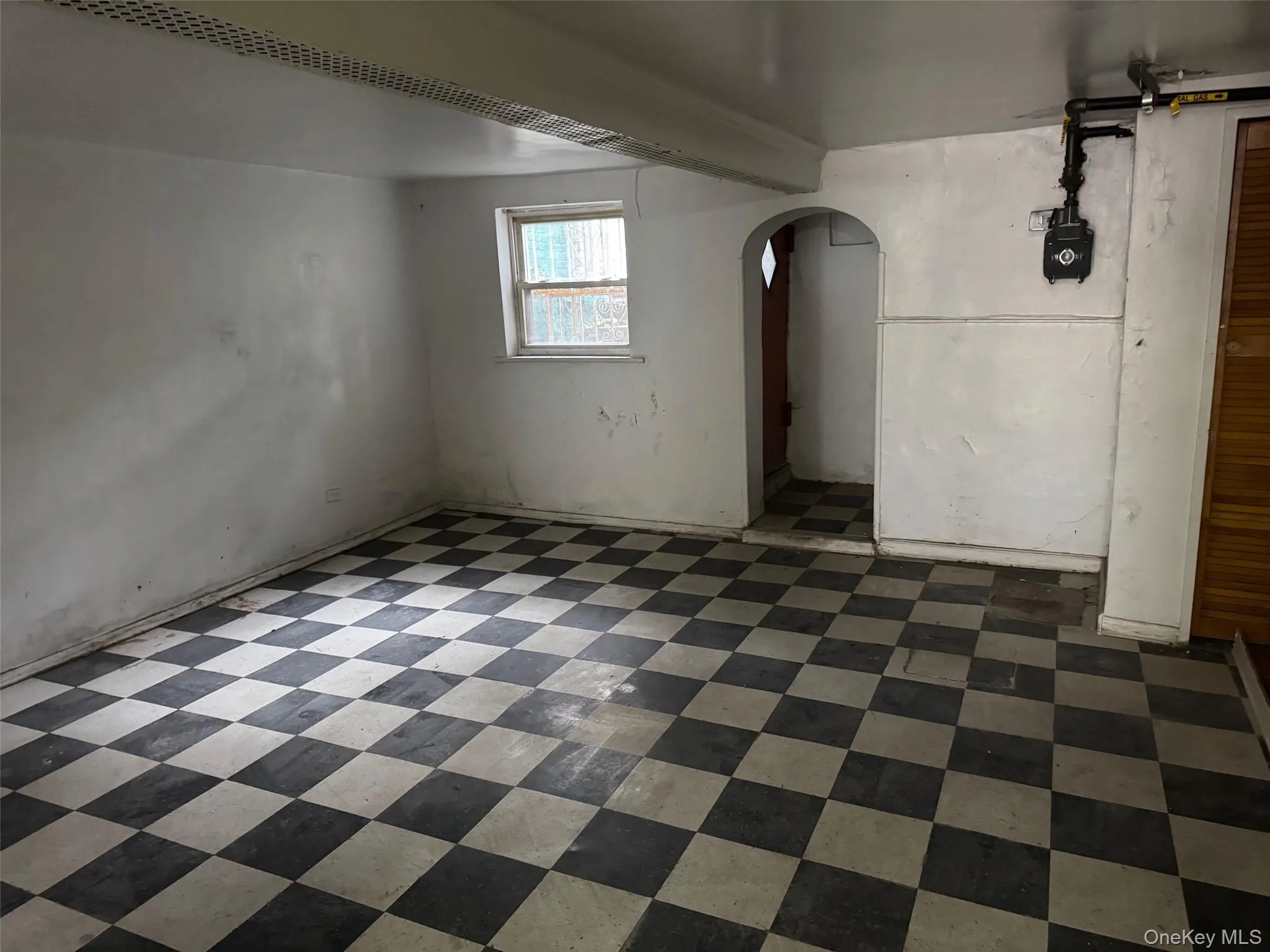 Below grade area featuring arched walkways and dark flooring Below grade area featuring arched walkways and dark flooring