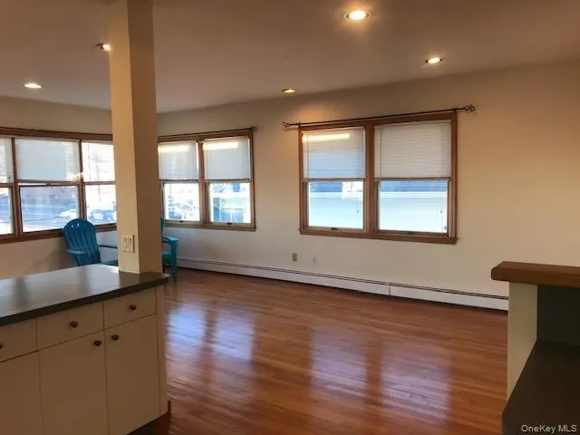 Kitchen with a baseboard radiator, dark countertops, dark wood-type flooring, and recessed lighting Kitchen with a baseboard radiator, dark countertops, dark wood-type flooring, and recessed lighting