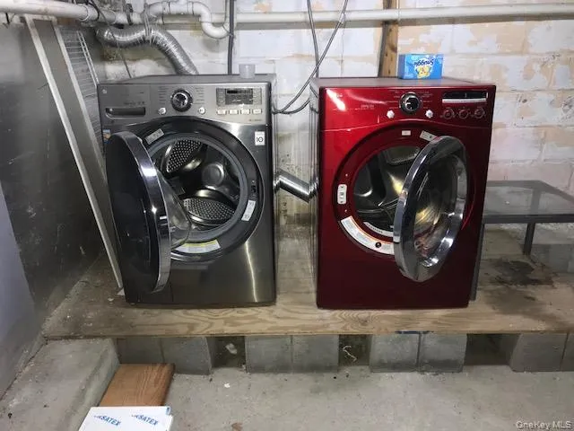 Laundry room featuring washing machine and dryer and unfinished concrete floors Laundry room featuring washing machine and dryer and unfinished concrete floors