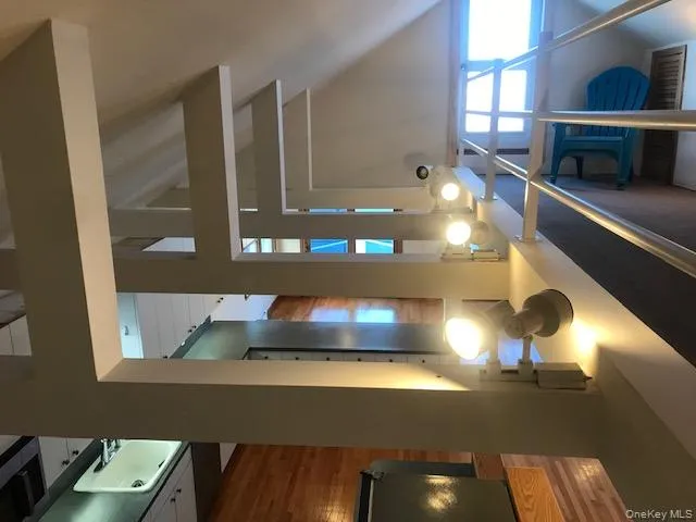 Staircase featuring high vaulted ceiling and wood finished floors Staircase featuring high vaulted ceiling and wood finished floors