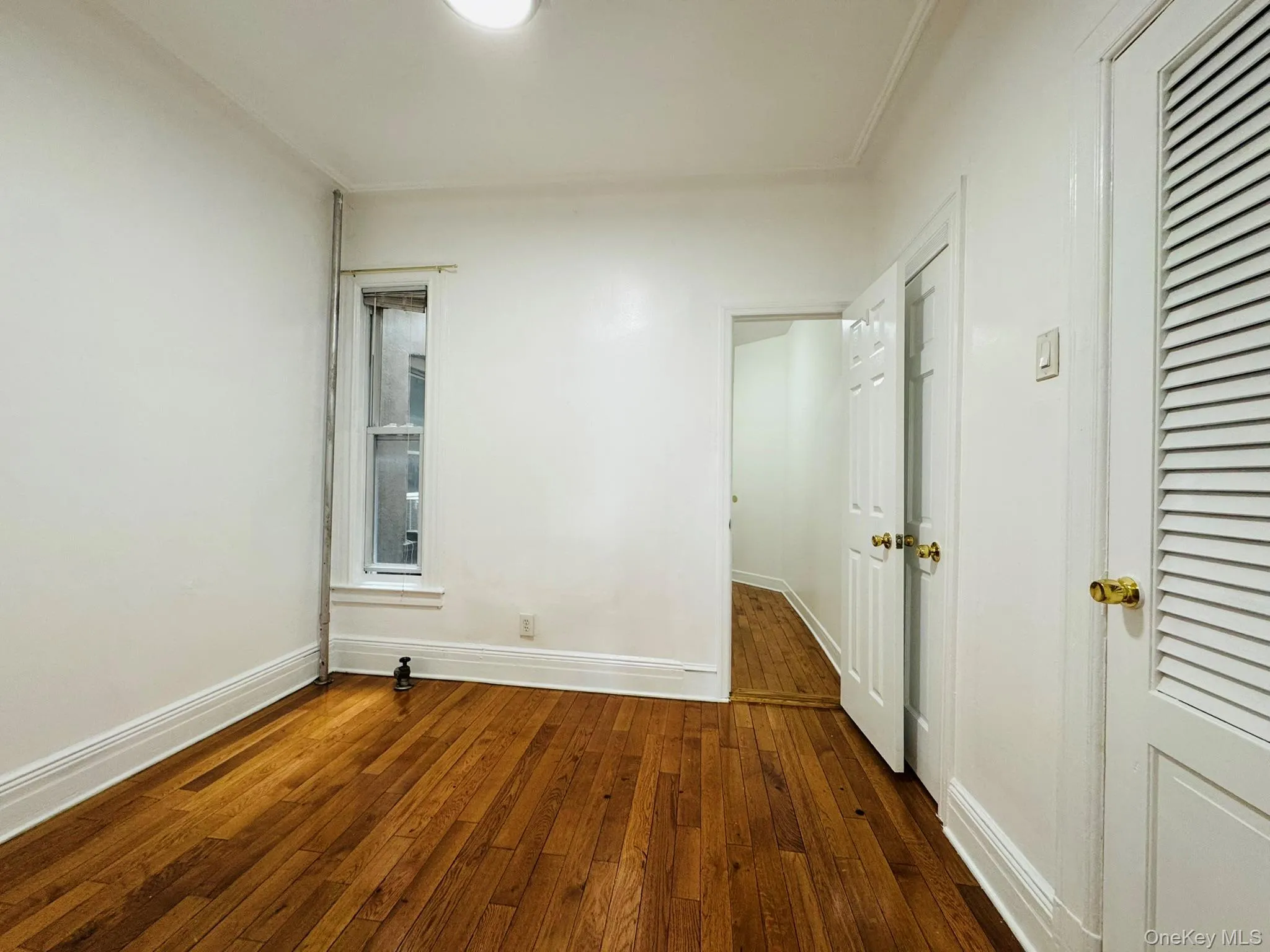 Unfurnished room featuring dark wood-style floors and baseboards Unfurnished room featuring dark wood-style floors and baseboards
