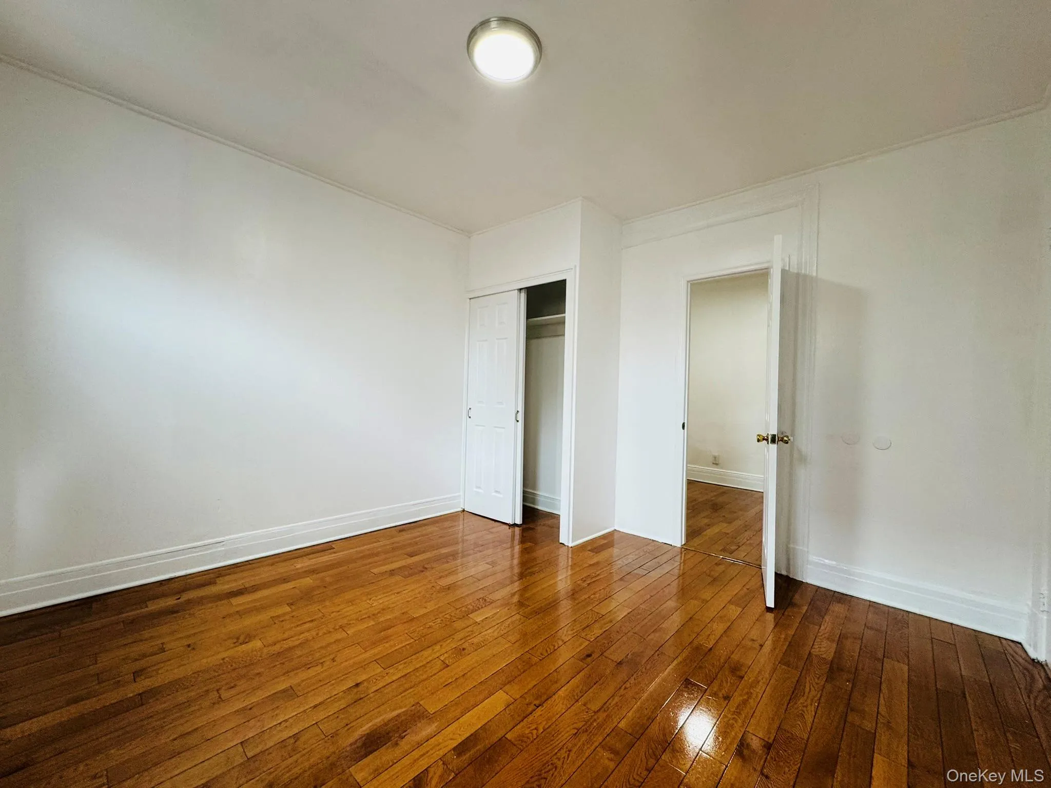 Unfurnished bedroom featuring dark wood-style floors and a closet Unfurnished bedroom featuring dark wood-style floors and a closet