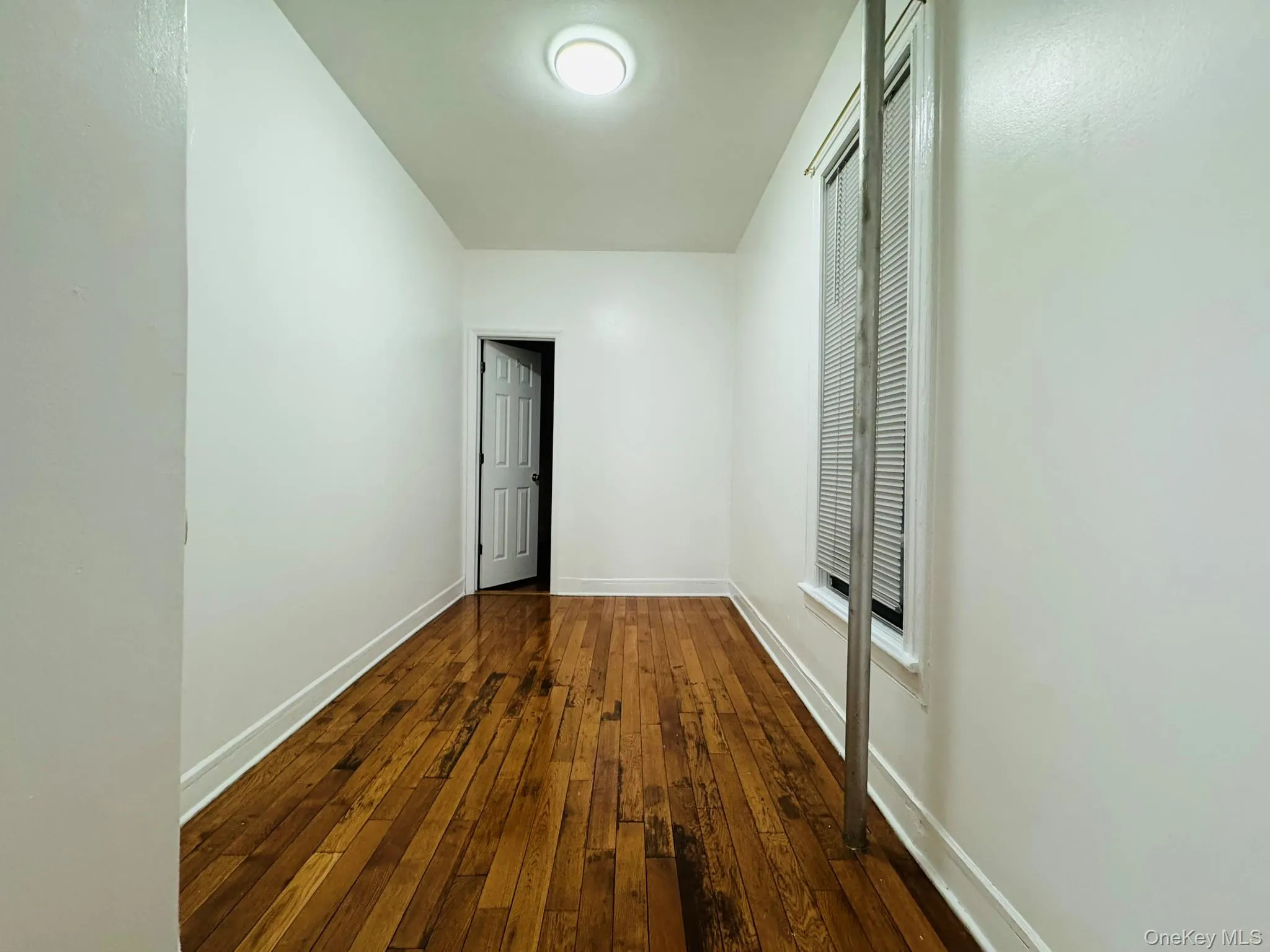 Unfurnished bedroom with dark wood-type flooring and baseboards Unfurnished bedroom with dark wood-type flooring and baseboards