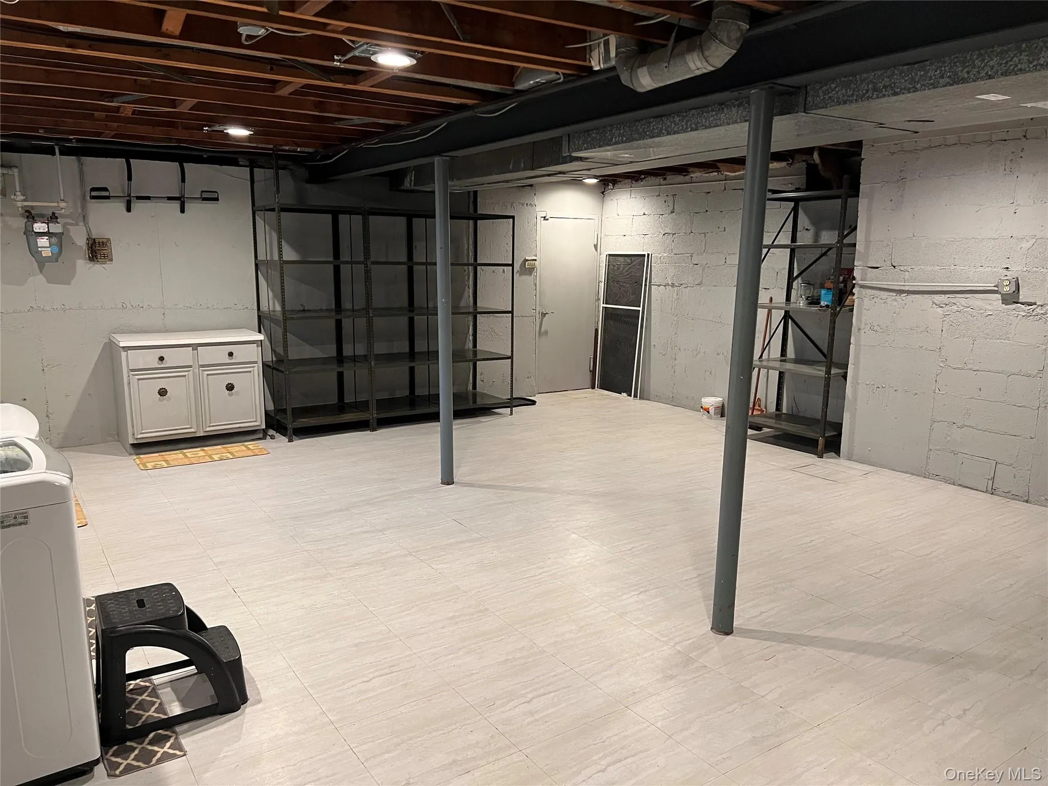 Unfinished basement featuring washer / dryer and light flooring Unfinished basement featuring washer / dryer and light flooring