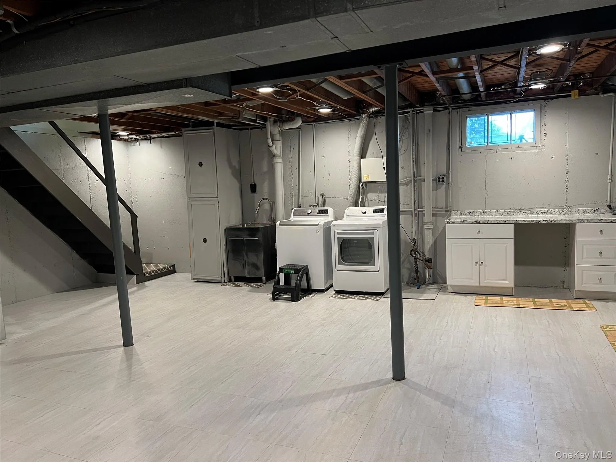 Basement featuring stairs and washer and clothes dryer Basement featuring stairs and washer and clothes dryer