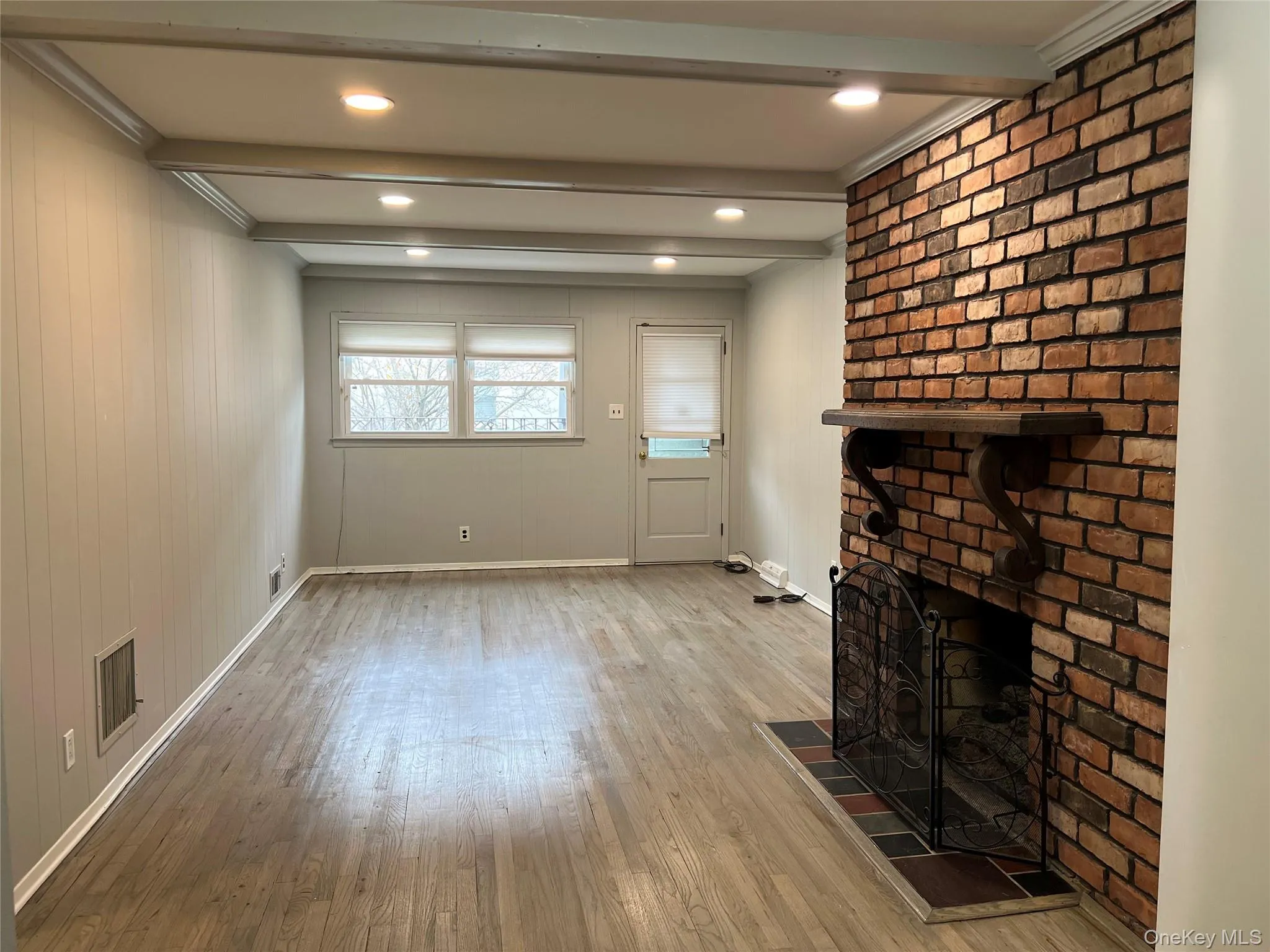 Unfurnished living room with beamed ceiling, light wood-style floors, a fireplace, recessed lighting, and crown molding Unfurnished living room with beamed ceiling, light wood-style floors, a fireplace, recessed lighting, and crown molding