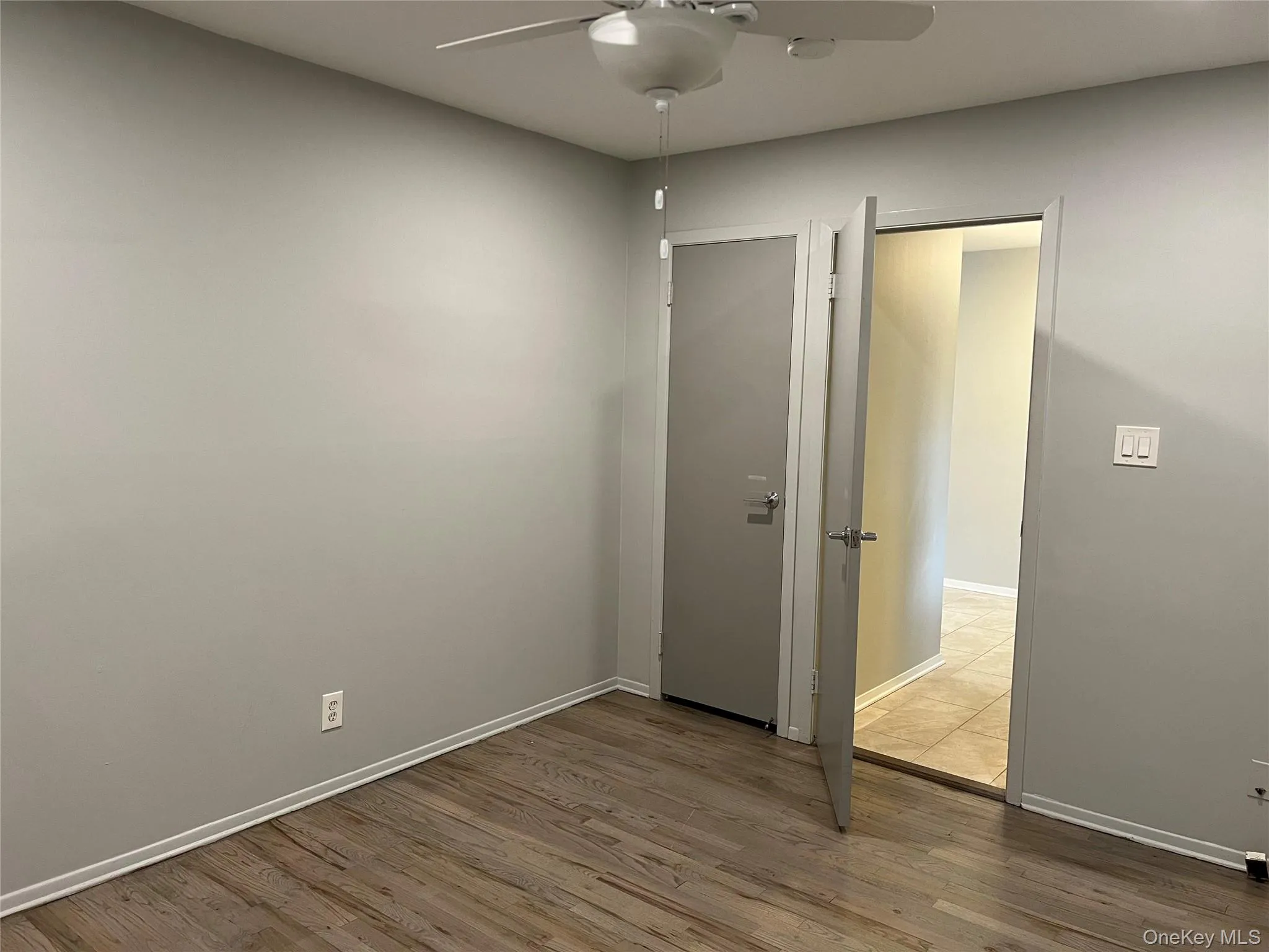 Empty room with wood finished floors and ceiling fan Empty room with wood finished floors and ceiling fan