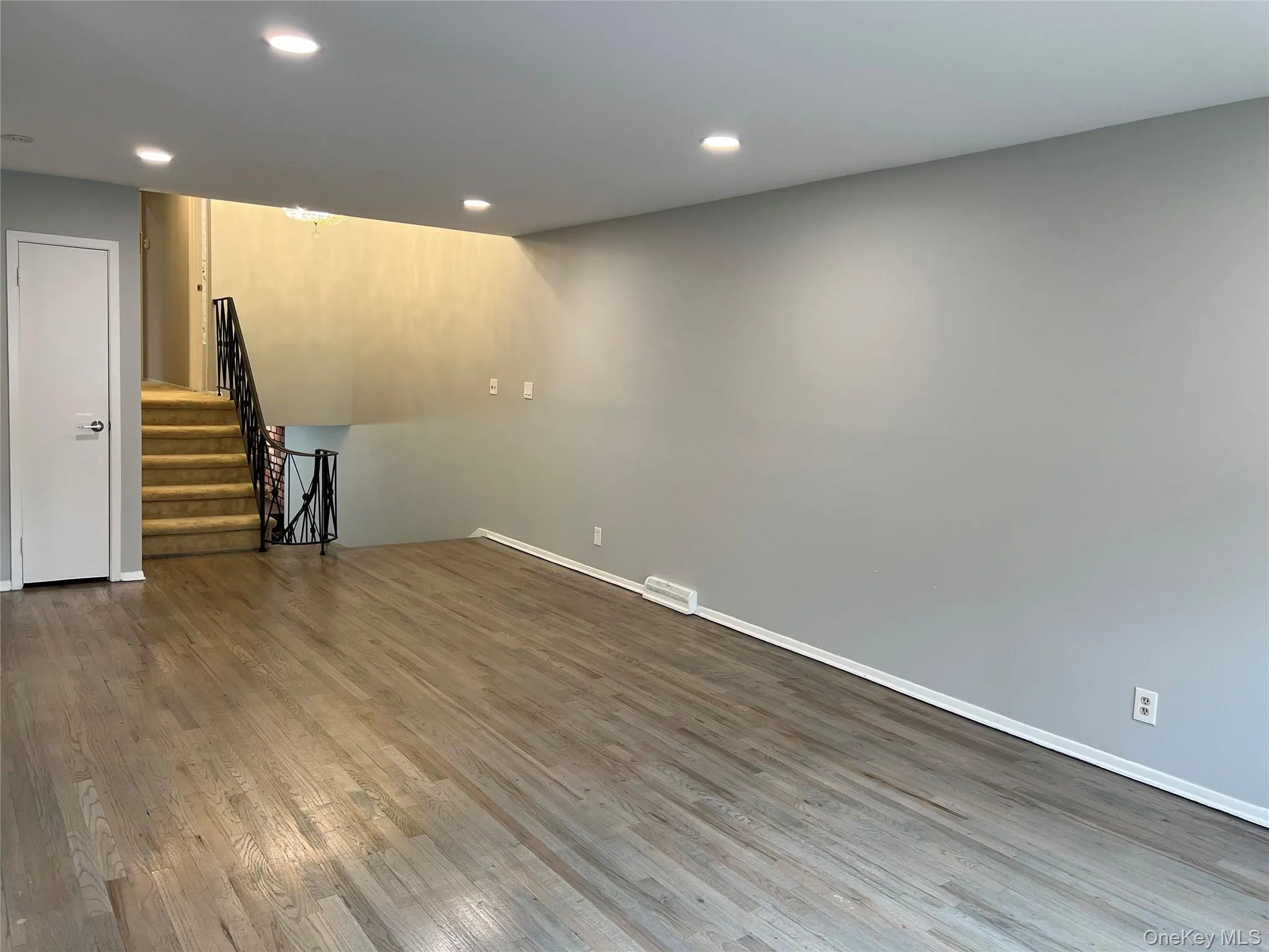 Below grade area featuring recessed lighting, wood finished floors, and stairs Below grade area featuring recessed lighting, wood finished floors, and stairs