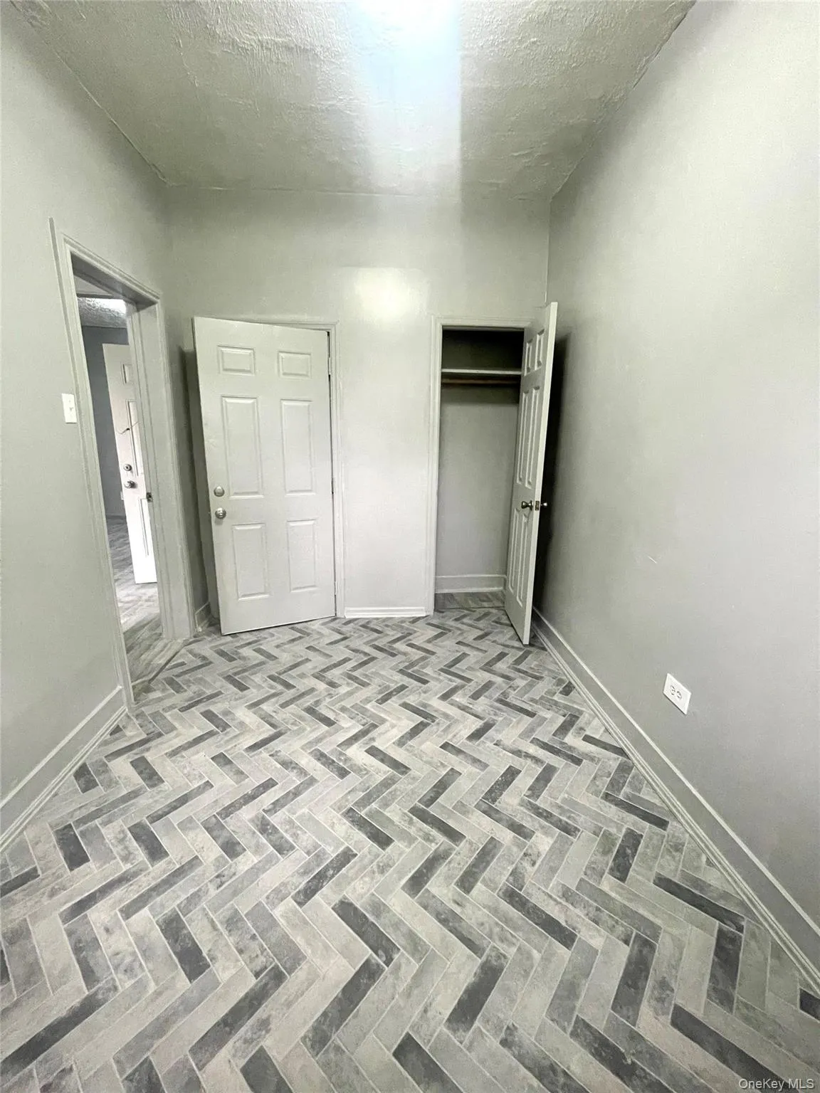 Unfurnished bedroom featuring a textured ceiling and a closet Unfurnished bedroom featuring a textured ceiling and a closet