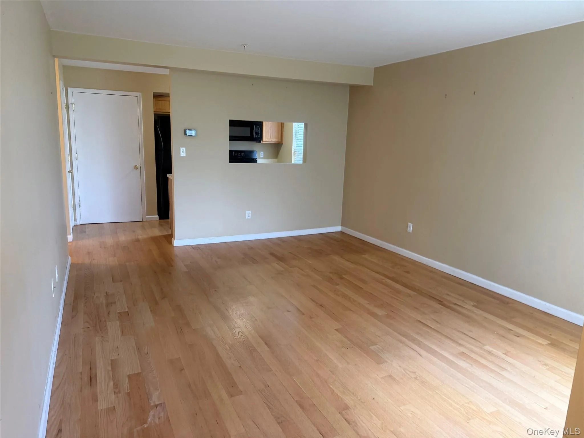 Empty room with light wood-style flooring and baseboards Empty room with light wood-style flooring and baseboards