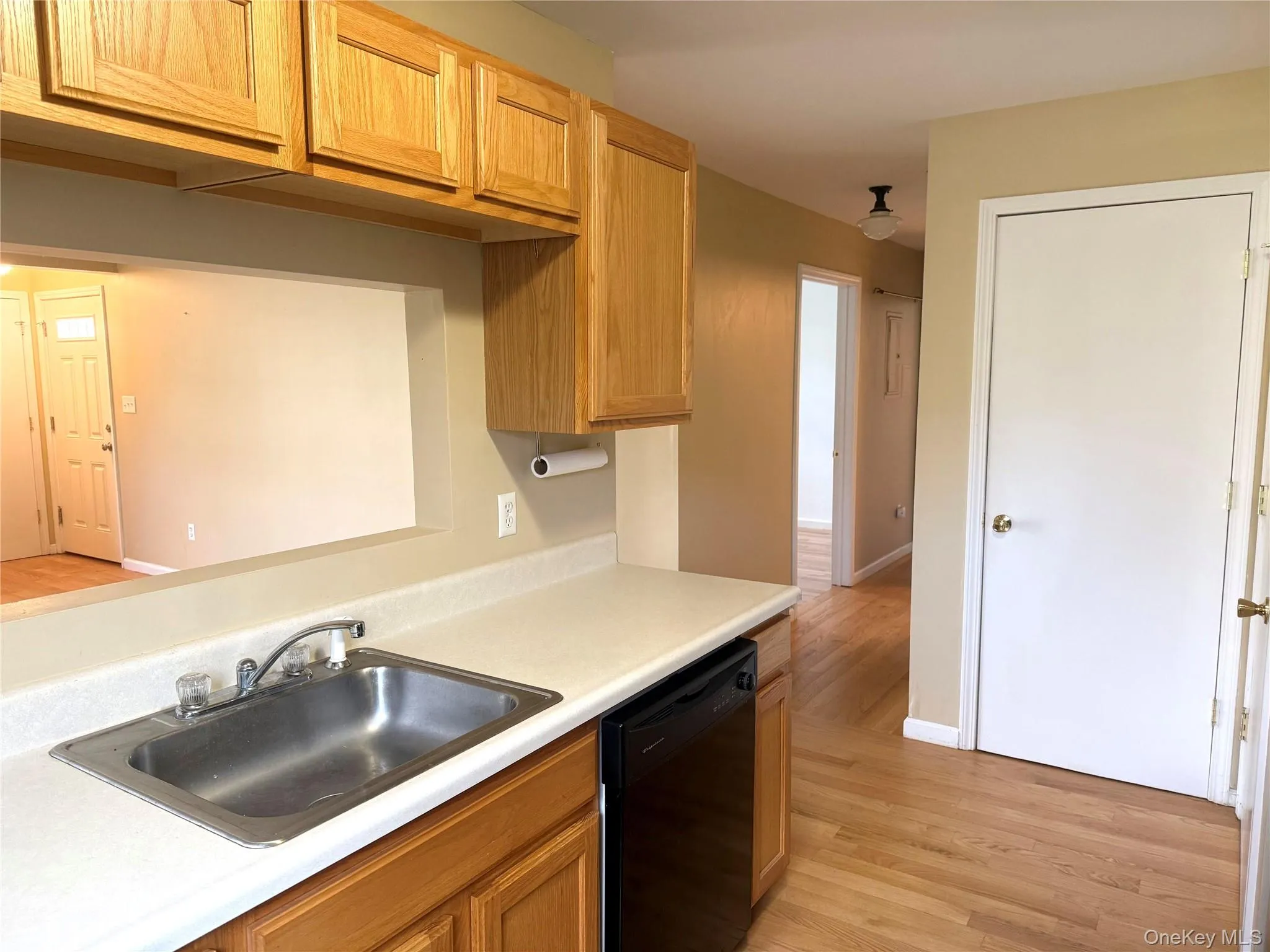 Kitchen featuring light wood-type flooring, light countertops, and dishwasher Kitchen featuring light wood-type flooring, light countertops, and dishwasher