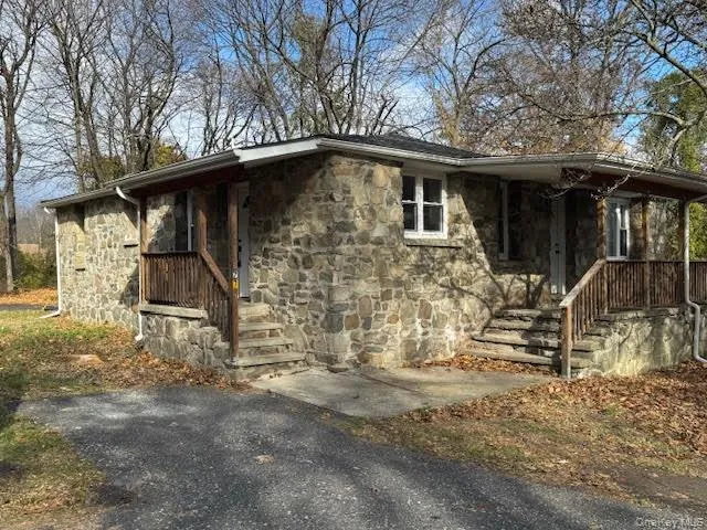 View of side of home featuring stone siding and covered porch View of side of home featuring stone siding and covered porch