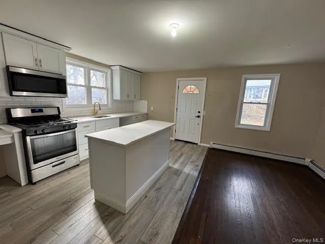 Kitchen with appliances with stainless steel finishes, light countertops, backsplash, and plenty of natural light Kitchen with appliances with stainless steel finishes, light countertops, backsplash, and plenty of natural light