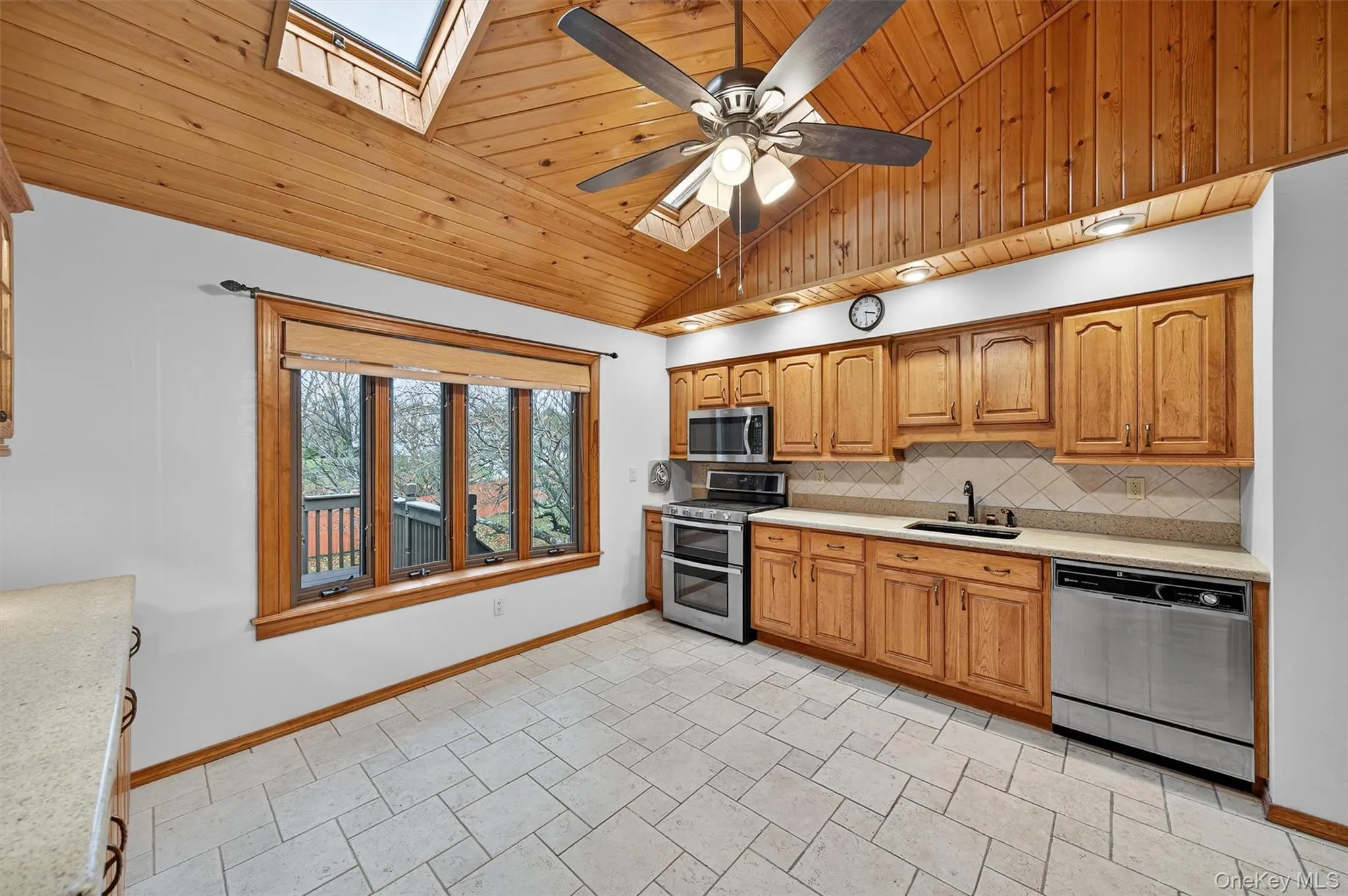Kitchen featuring a skylight, vaulted ceiling, stainless steel appliances. Kitchen featuring a skylight, vaulted ceiling, stainless steel appliances.