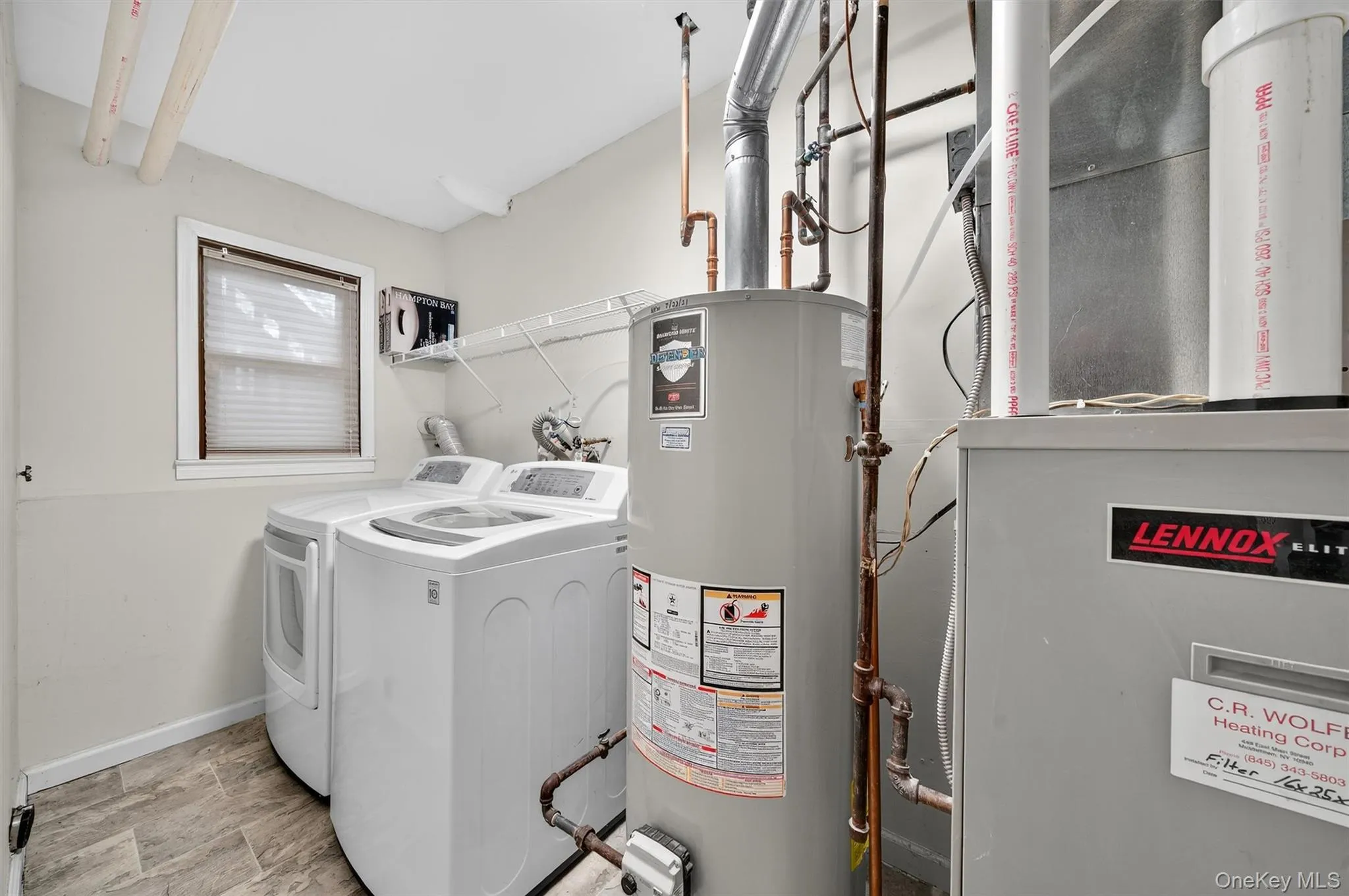 Washroom with heating unit, gas water heater, washing machine and clothes dryer, and stone finish flooring Washroom with heating unit, gas water heater, washing machine and clothes dryer, and stone finish flooring