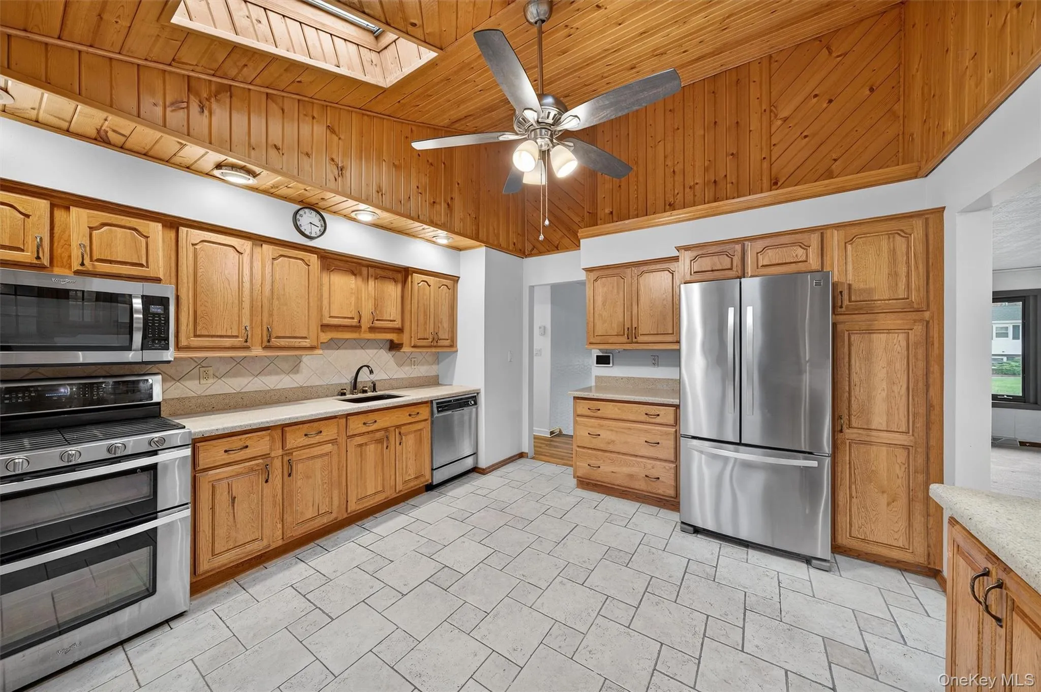 Kitchen featuring a skylight, vaulted ceiling, stainless steel appliances. Kitchen featuring a skylight, vaulted ceiling, stainless steel appliances.