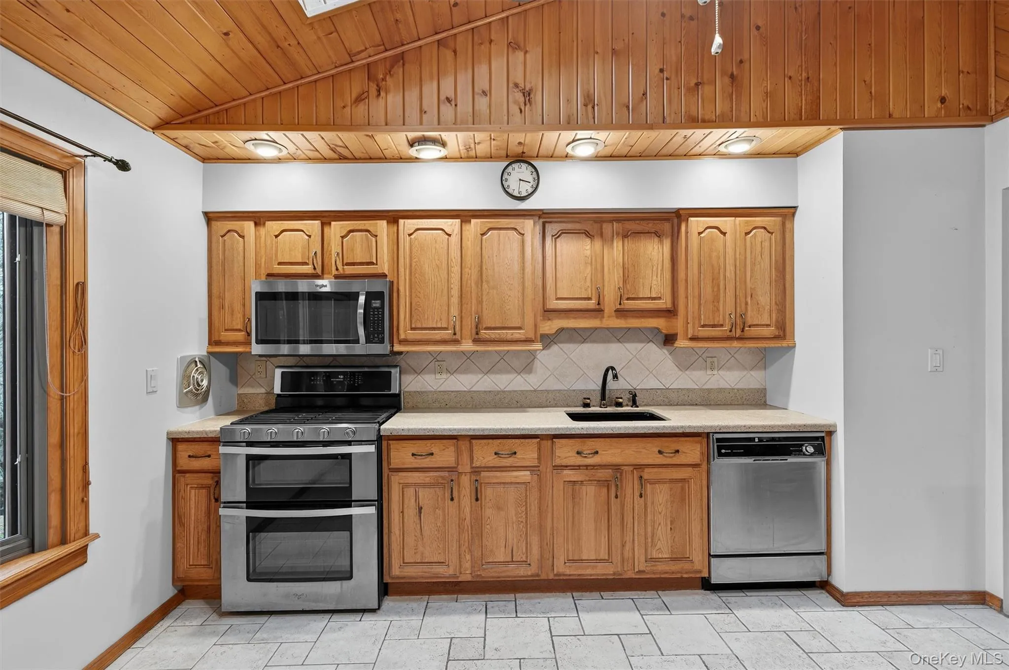 Kitchen featuring a skylight, vaulted ceiling, stainless steel appliances. Kitchen featuring a skylight, vaulted ceiling, stainless steel appliances.