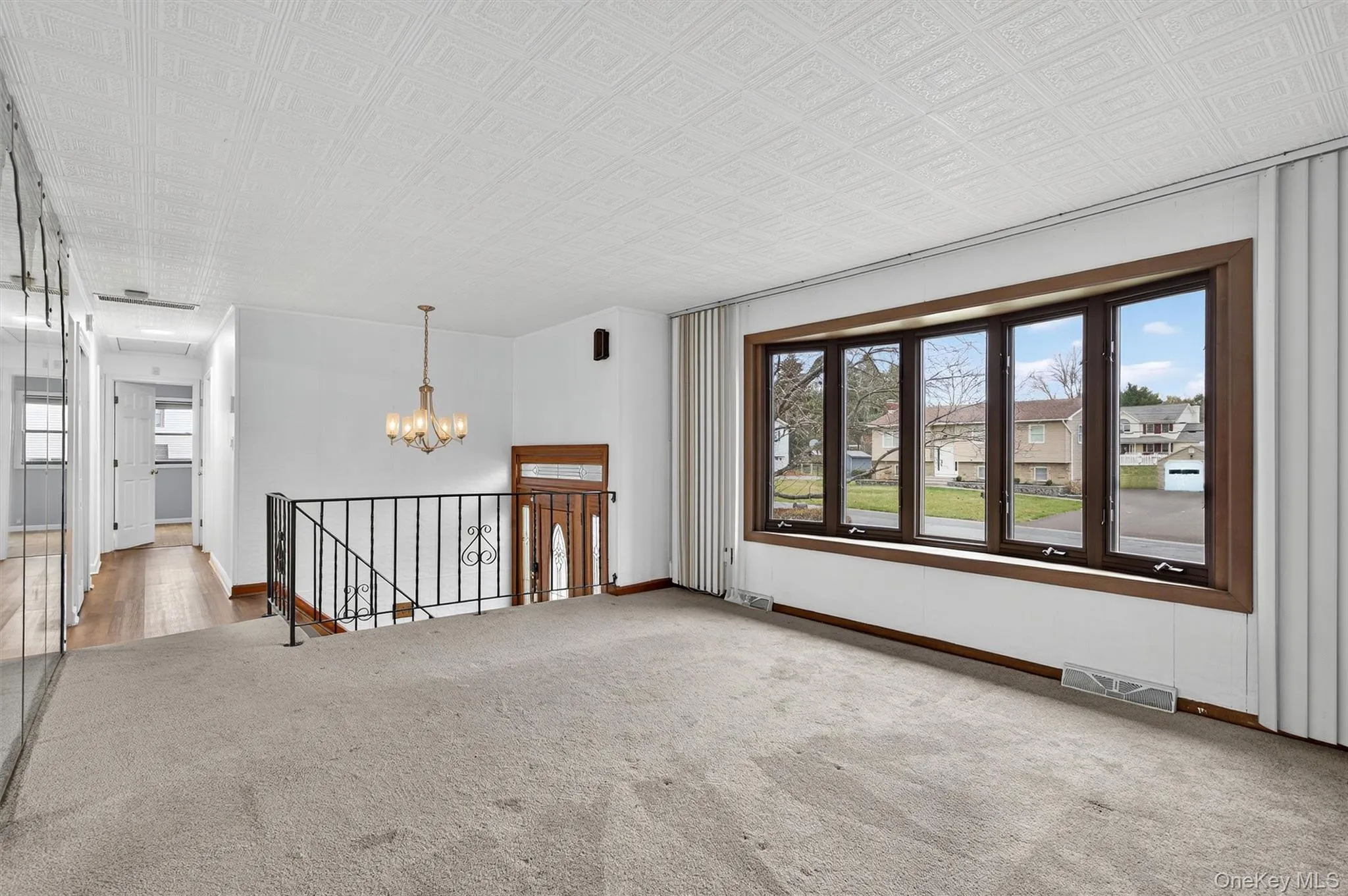 Carpeted spare room featuring an ornate ceiling and a chandelier Carpeted spare room featuring an ornate ceiling and a chandelier