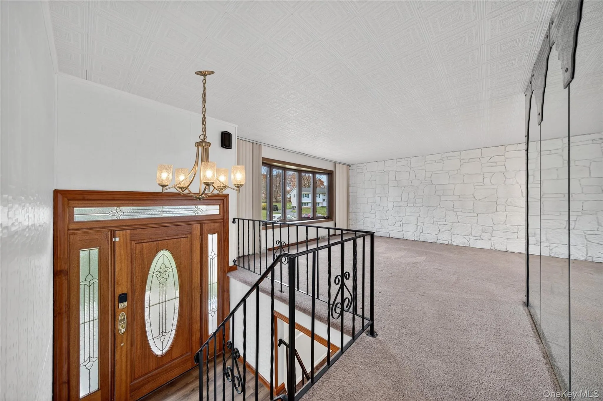 Carpeted entryway featuring an ornate ceiling and a chandelier Carpeted entryway featuring an ornate ceiling and a chandelier