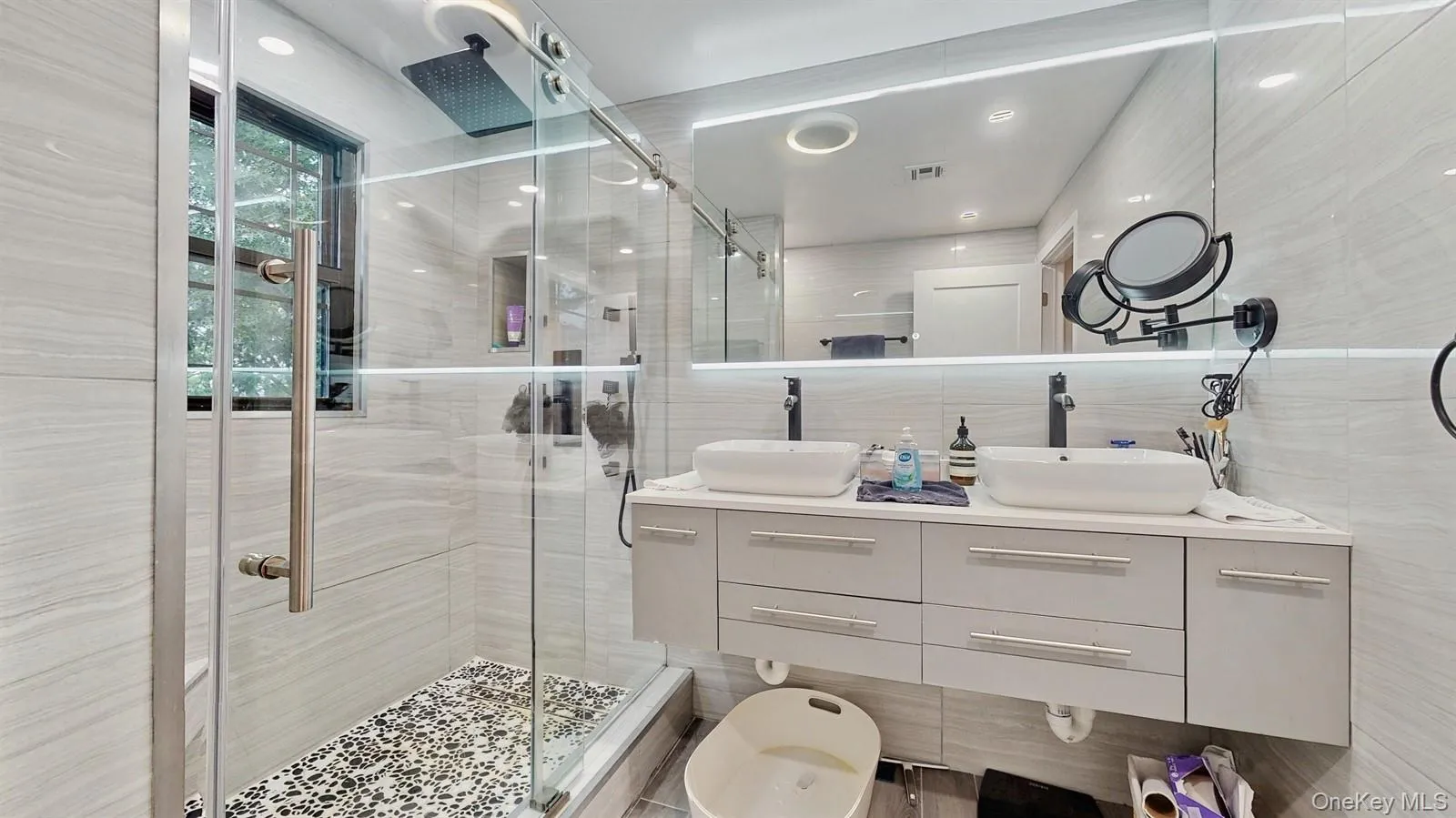 Gorgeous Bathroom with ceramic tiled walls, a glass-enclosed shower and double bowl quartz counter top vanity. Gorgeous Bathroom with ceramic tiled walls, a glass-enclosed shower and double bowl quartz counter top vanity.