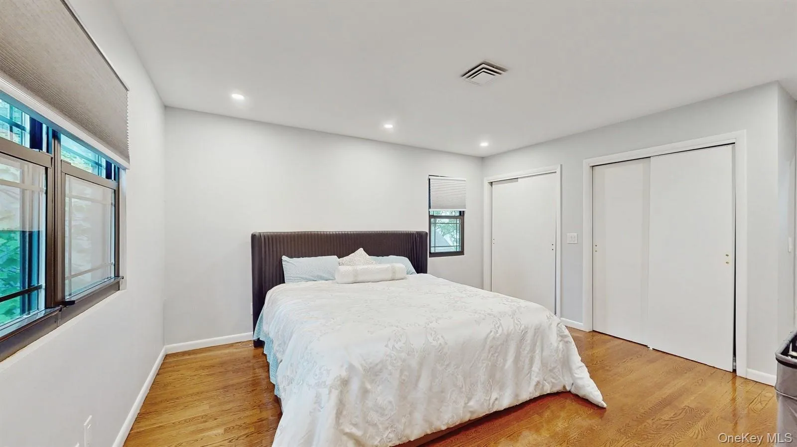 Huge, Primary Bedroom, featuring multiple closets, multiple windows, light hardwood floors, and recessed lighting. Huge, Primary Bedroom, featuring multiple closets, multiple windows, light hardwood floors, and recessed lighting.