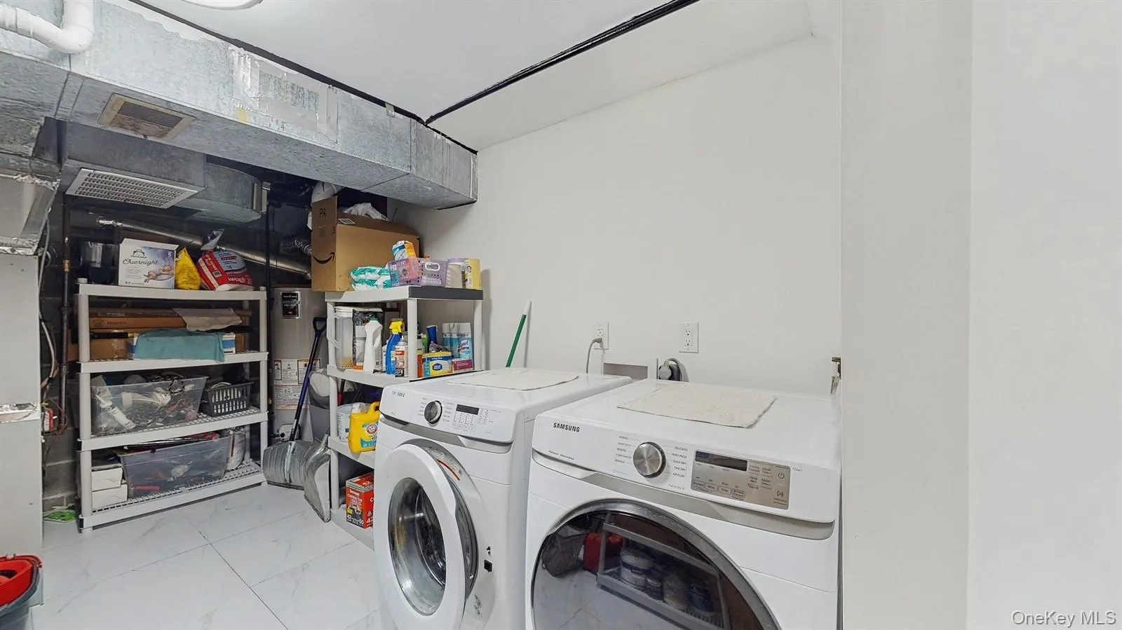Washroom with marble tiles, washing machine and clothes dryer. Washroom with marble tiles, washing machine and clothes dryer.