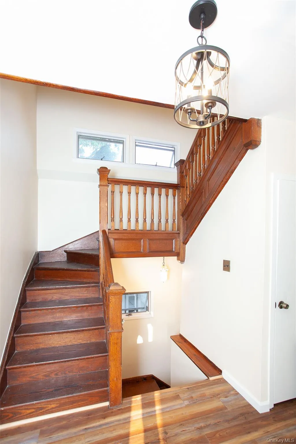 Stairway with wood finished floors and a chandelier Stairway with wood finished floors and a chandelier