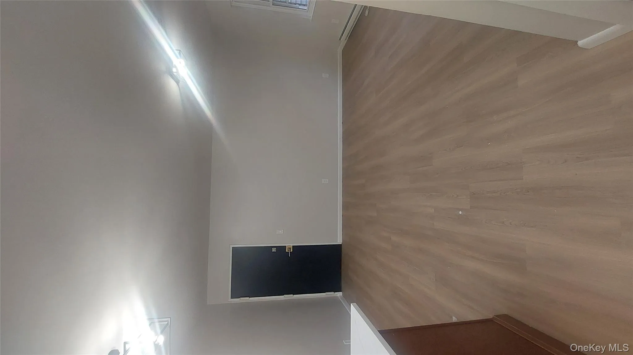 Empty room with light wood finished floors and baseboard heating Empty room with light wood finished floors and baseboard heating