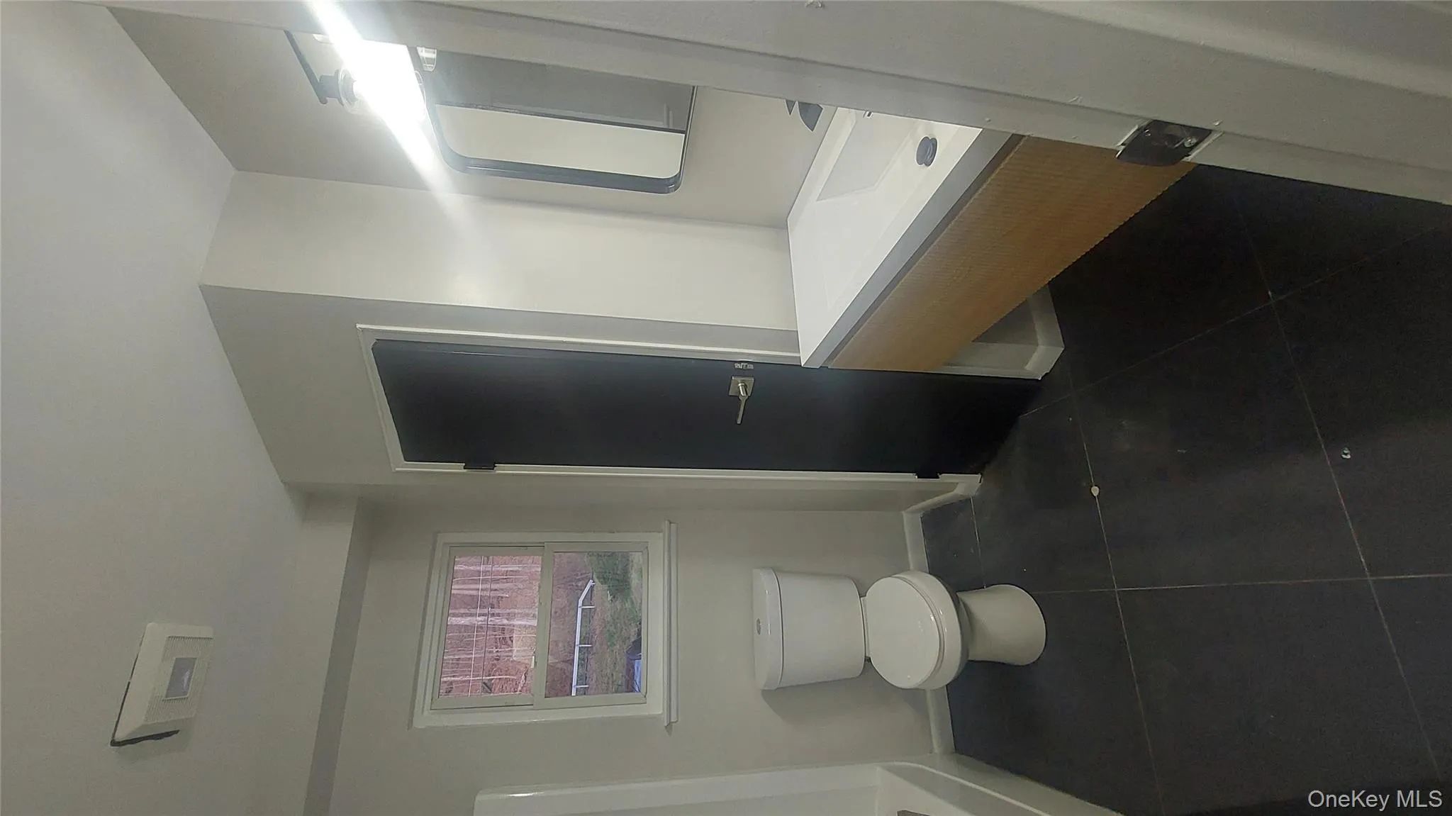 Full bath featuring dark tile patterned flooring and vanity Full bath featuring dark tile patterned flooring and vanity