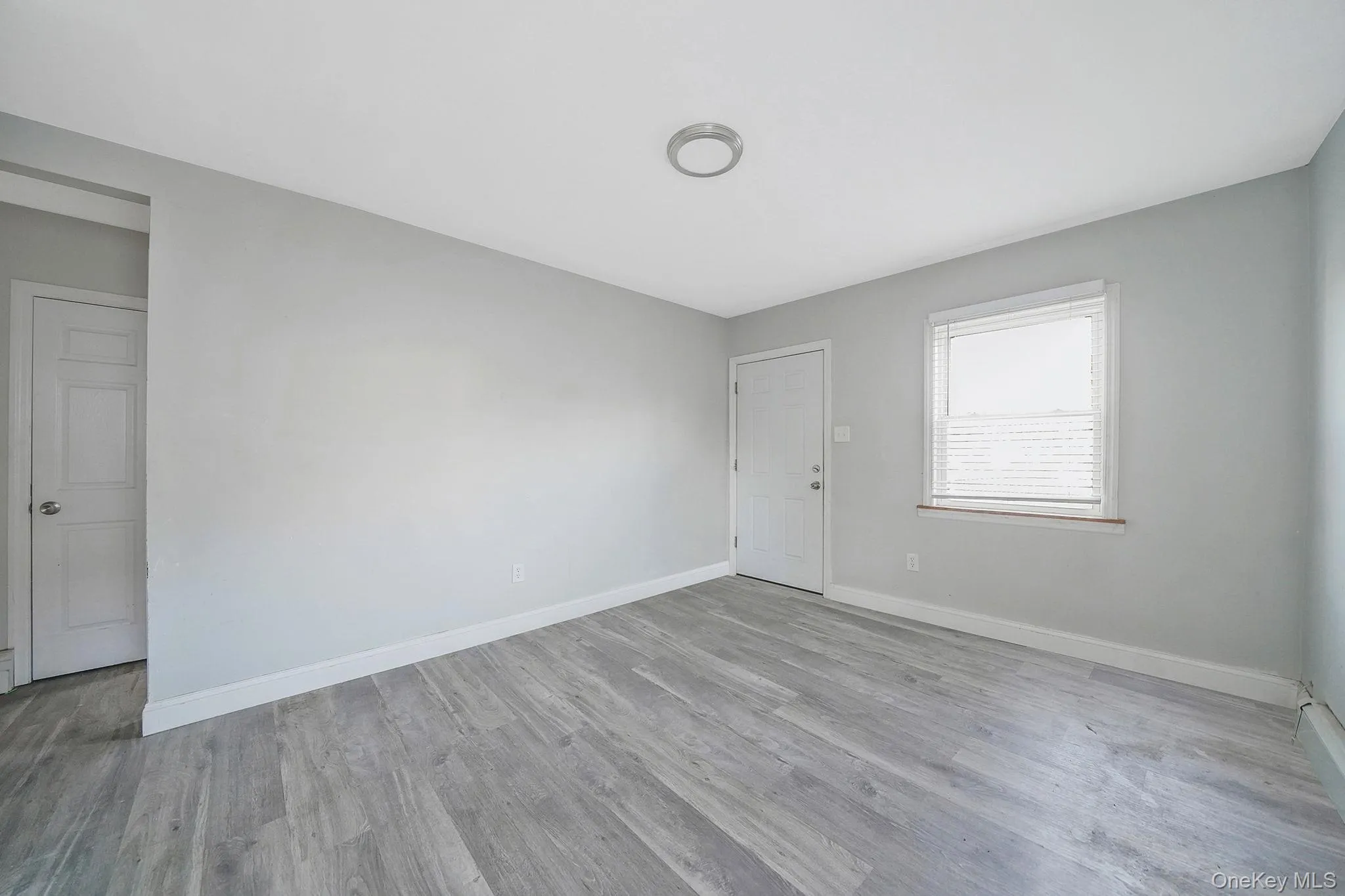 Unfurnished room with light wood finished floors and baseboards Unfurnished room with light wood finished floors and baseboards