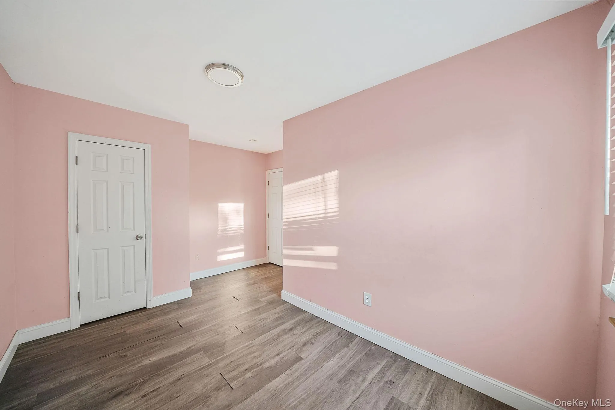 Unfurnished bedroom featuring wood finished floors and baseboards Unfurnished bedroom featuring wood finished floors and baseboards