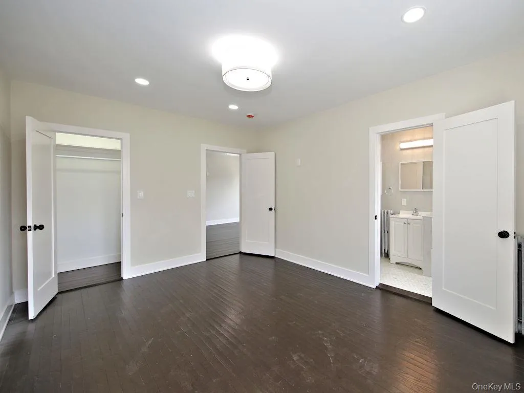 Unfurnished bedroom featuring recessed lighting, dark wood-type flooring, and a closet Unfurnished bedroom featuring recessed lighting, dark wood-type flooring, and a closet