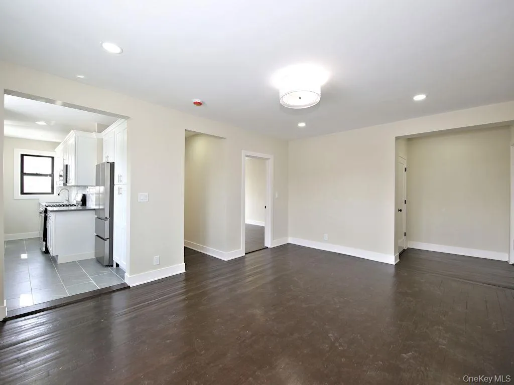 Unfurnished living room featuring recessed lighting and dark wood finished floors Unfurnished living room featuring recessed lighting and dark wood finished floors