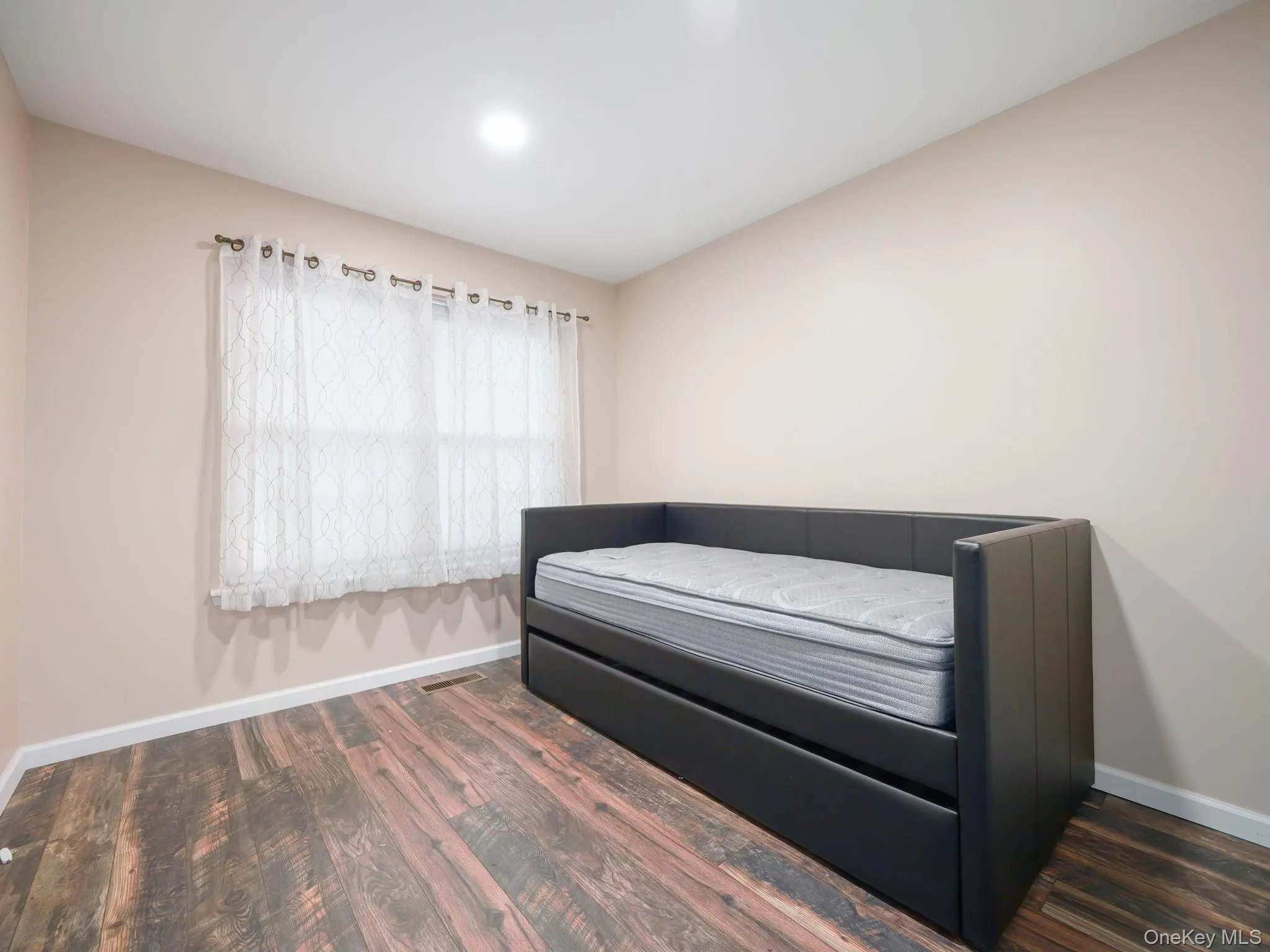 Bedroom with baseboards and dark wood-style flooring Bedroom with baseboards and dark wood-style flooring