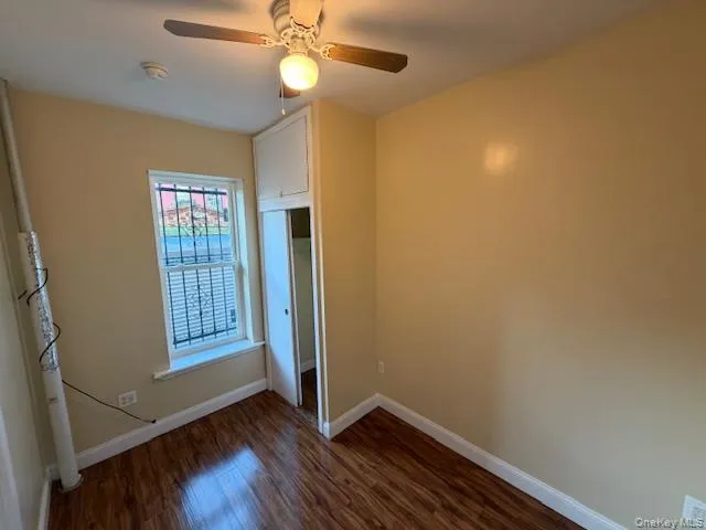Unfurnished bedroom with dark wood-style floors, ceiling fan, and a closet Unfurnished bedroom with dark wood-style floors, ceiling fan, and a closet
