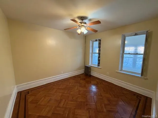 Unfurnished room with radiator and ceiling fan Unfurnished room with radiator and ceiling fan