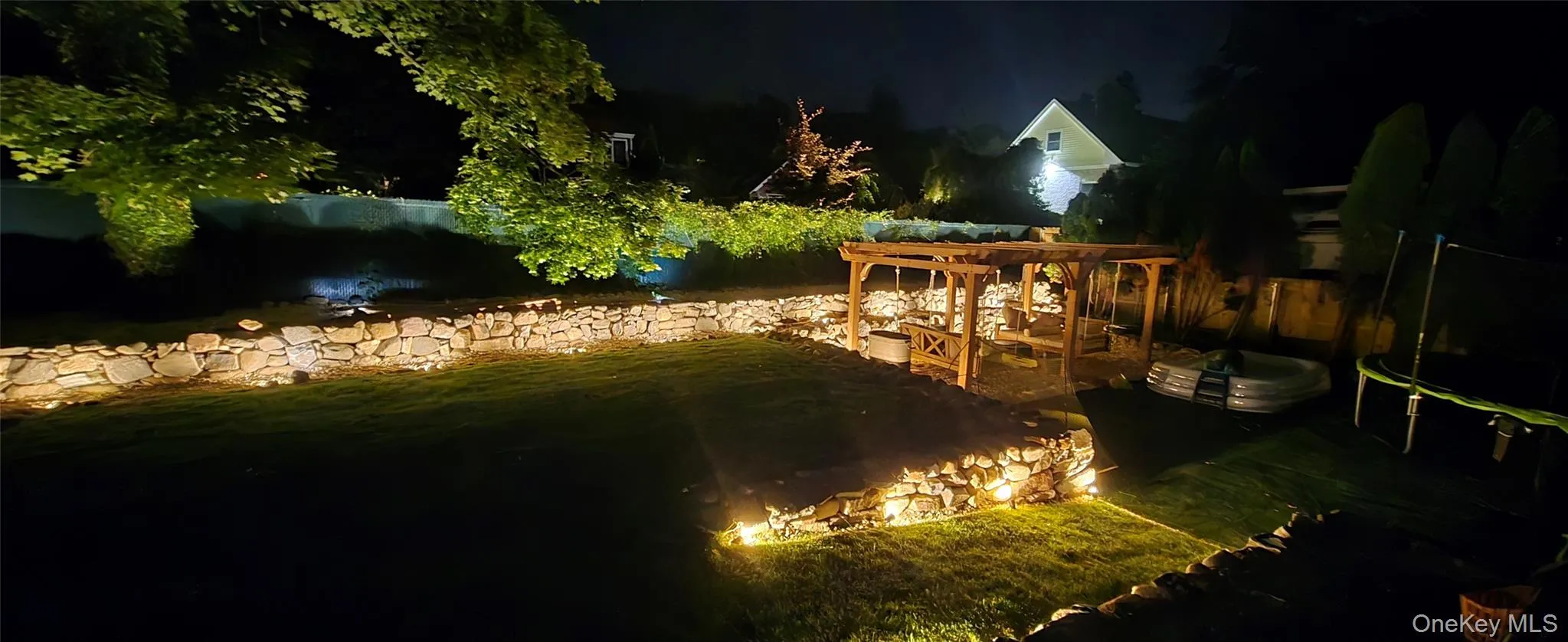 Yard at night featuring a patio area Yard at night featuring a patio area