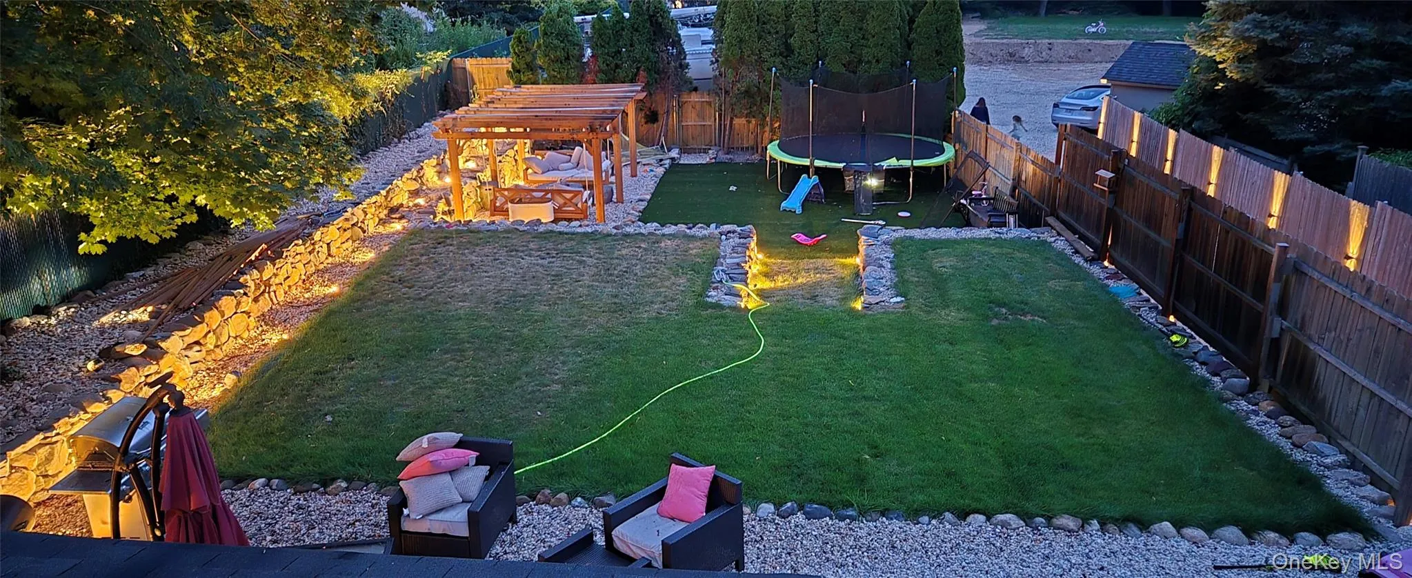 Fenced backyard featuring a trampoline and a playground Fenced backyard featuring a trampoline and a playground