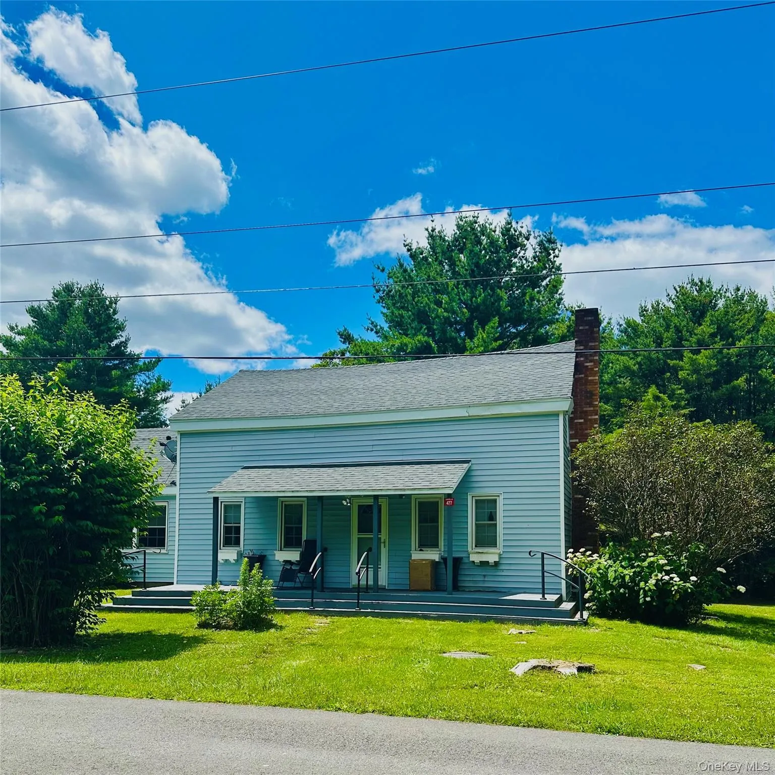 View of front of property featuring covered porch, a front yard, a chimney, and roof with shingles View of front of property featuring covered porch, a front yard, a chimney, and roof with shingles